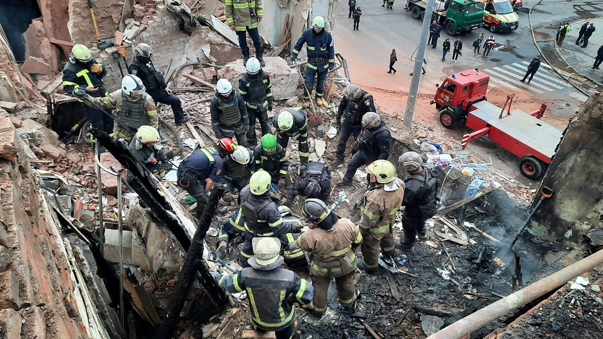 Ukrainian emergency service workers search through the rubble following a Russian Iskander missile strike