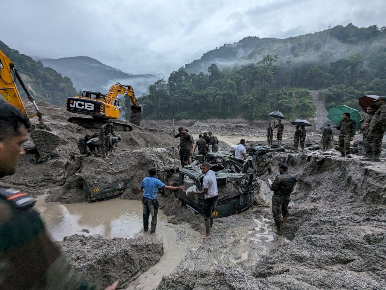 Members of Indian Army try to recover trucks buried at the area affected by flood in Sikkim