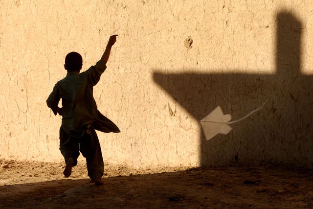 <p> A young Afghan boy flies a kite November 12, 2001 in a Afghan refugee district of Quetta, Pakistan. </p>