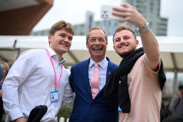 <p>Delegates at the Tory conference pose with Nigel Farage in Manchester</p>