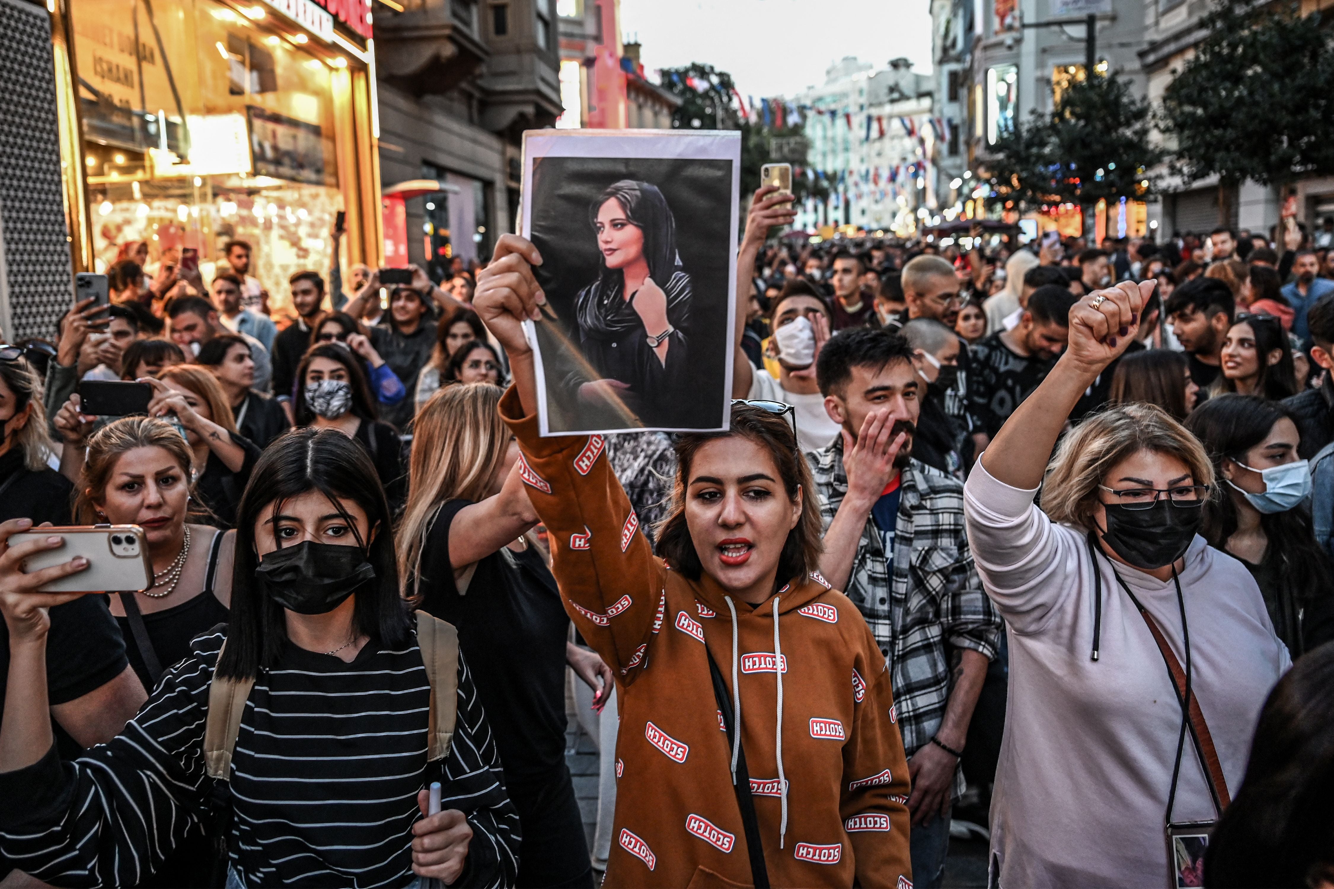 A protester holds a portrait of Mahsa Amini during a demonstration in support of the young Iranian woman who died after being arrested in Tehran
