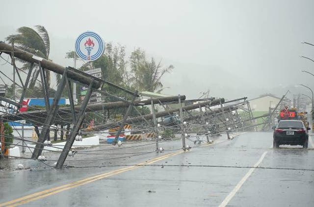 <p>A car passes by power lines downed by the high winds from Typhoon Koinu in Taiwan’s southern Pingtung County on 5 October 2023</p>