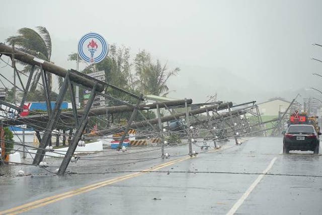 <p>A car passes by power lines downed by the high winds from Typhoon Koinu in Taiwan’s southern Pingtung County on 5 October 2023</p>