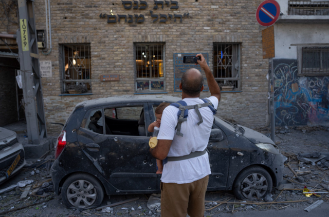 <p>Israelis inspect the rubble of a building a day after it was hit by a rocket fired from the Gaza Strip in Tel Aviv, Israel</p>