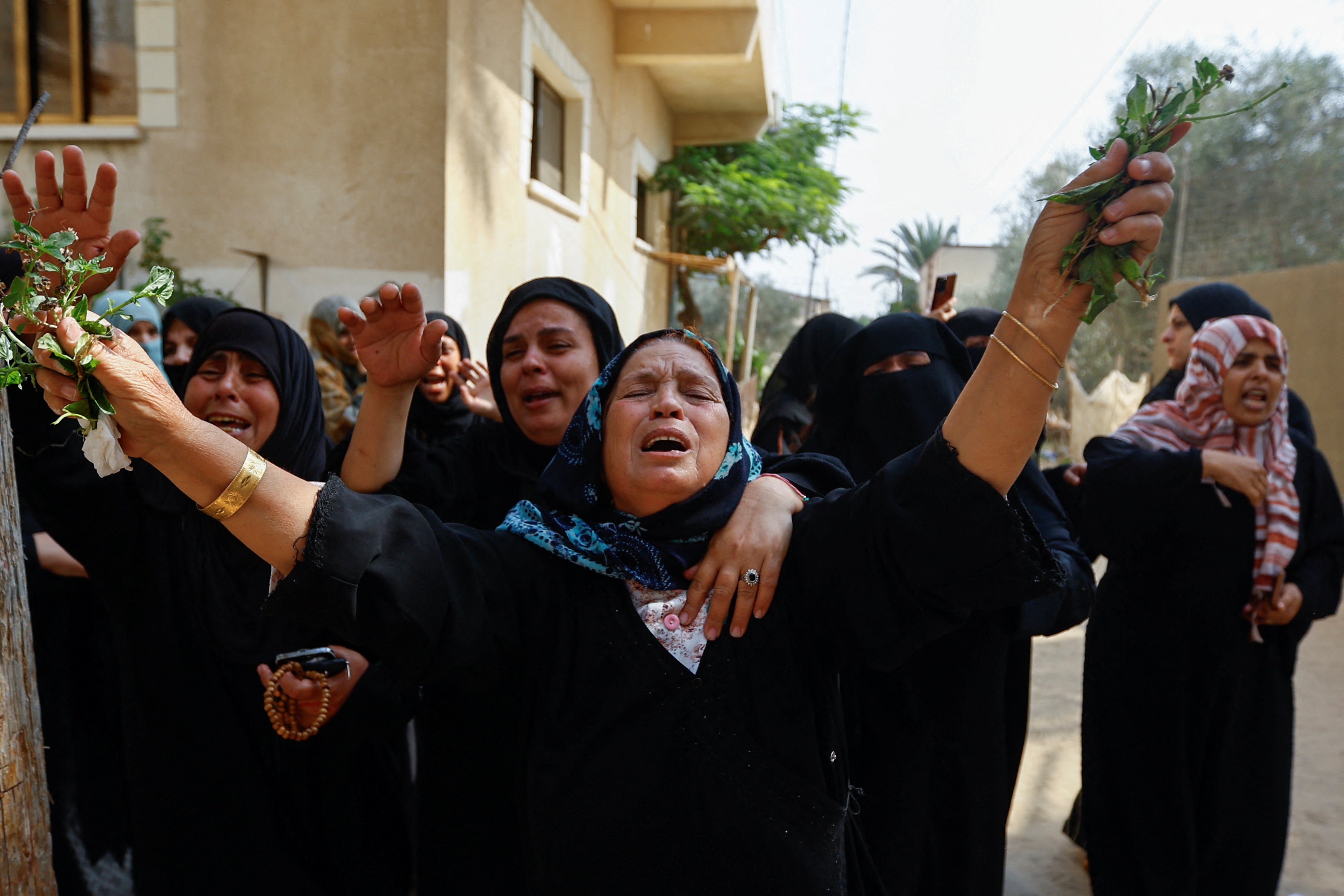 Relatives mourn after Israeli air strikes had hit housing blocks, tunnels, a mosque and homes of Hamas officials in Gaza