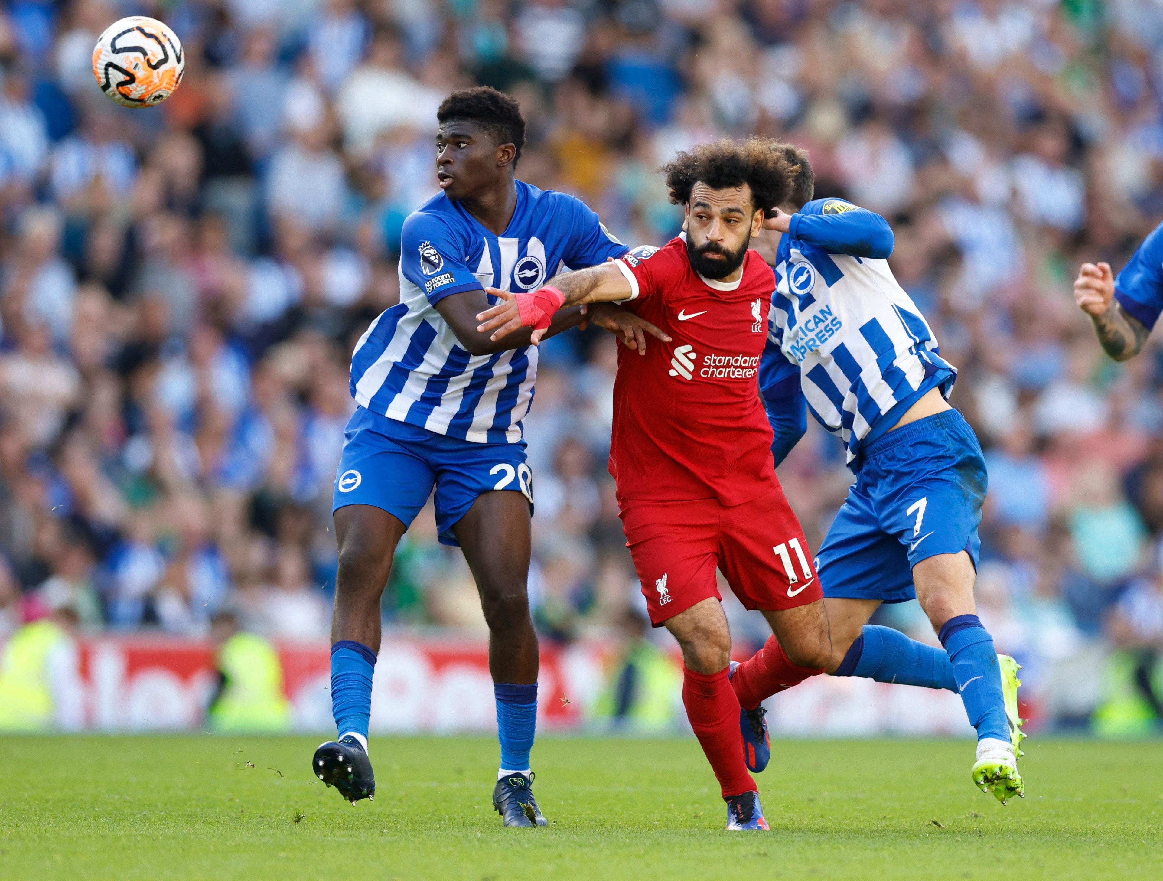 Carlos Baleba battles with Mohamed Salah for the ball