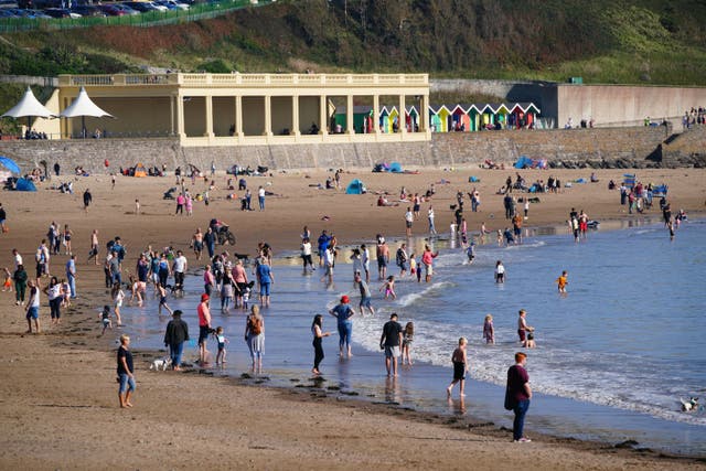 People enjoy the warm weather on the beach at Barry Island in the Vale of Glamorgan (Ben Birchall/PA)