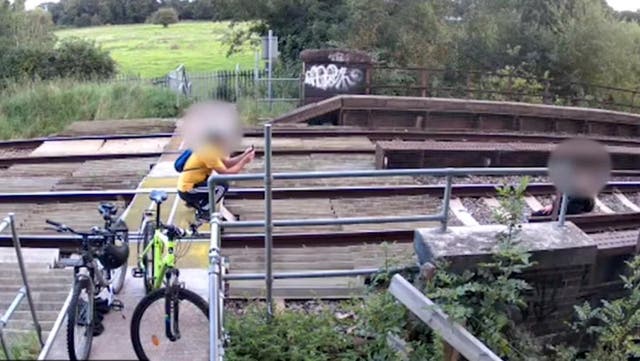 <p>Couple pose on railway track for a picture where trains speed by at 100mph.</p>