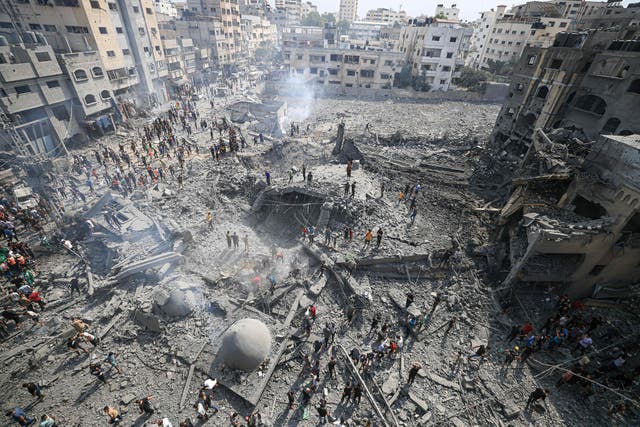 <p>Palestinians inspect the damage following an Israeli airstrike on the Sousi mosque in Gaza City</p>