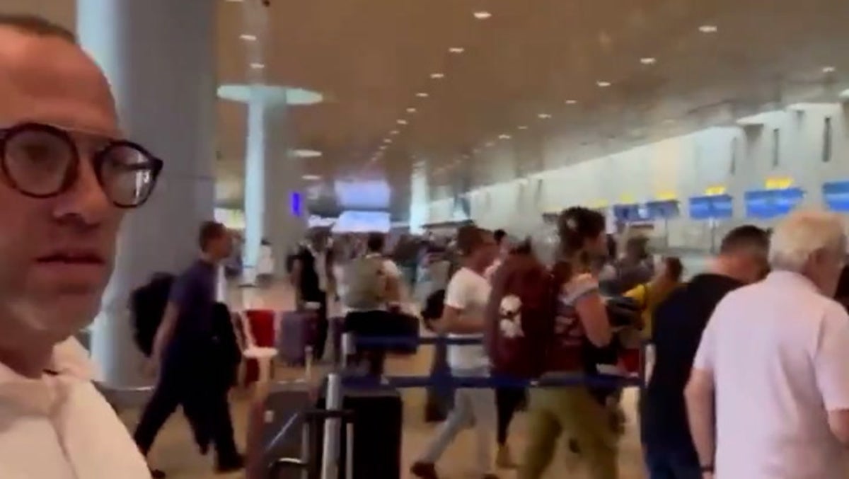 Desperate travellers ditch luggage and race to board planes out of Israel as rockets fired nearby