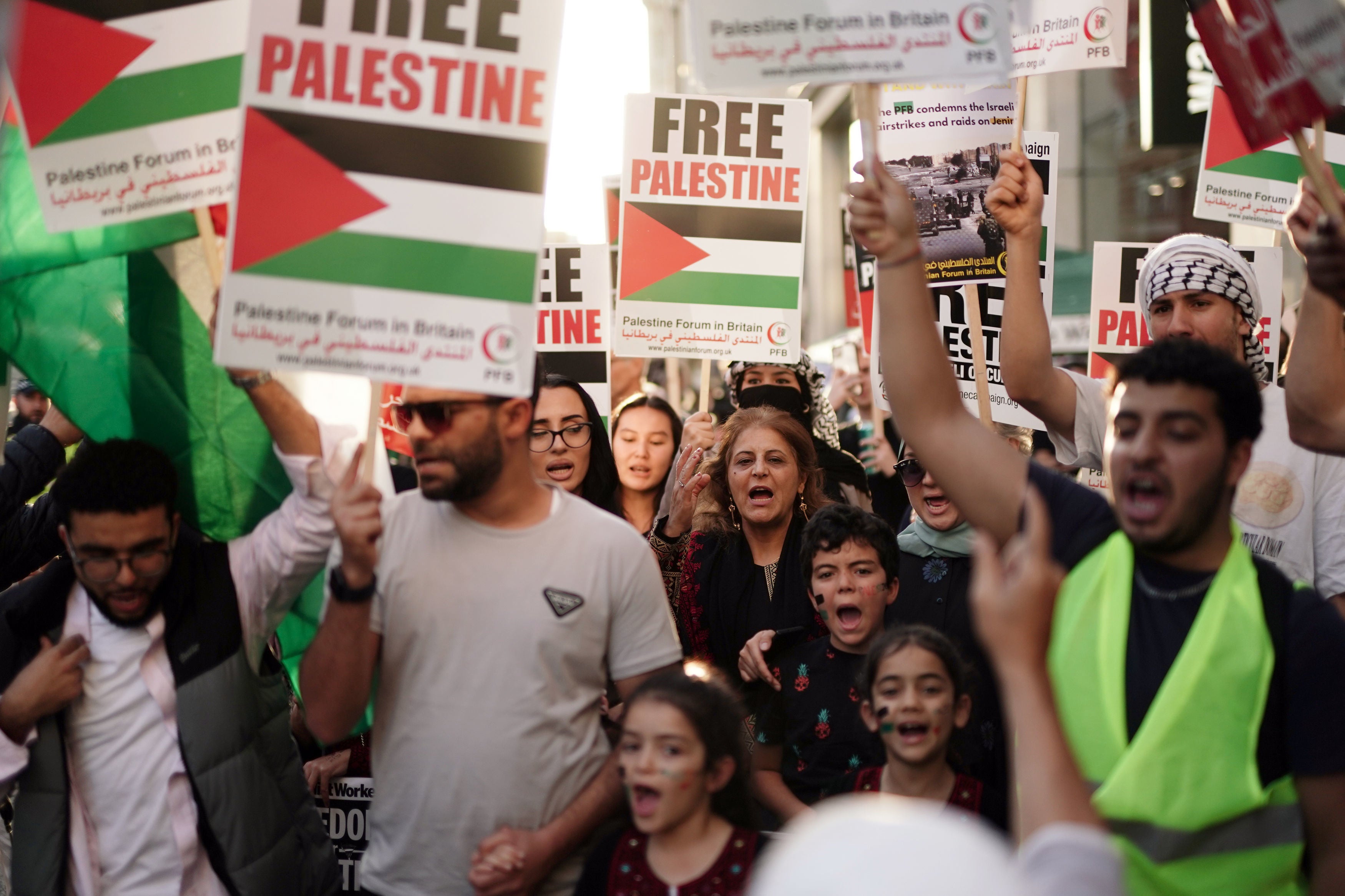 People take part in a Palestine Solidarity Campaign demonstration near the Israeli Embassy in Kensingston
