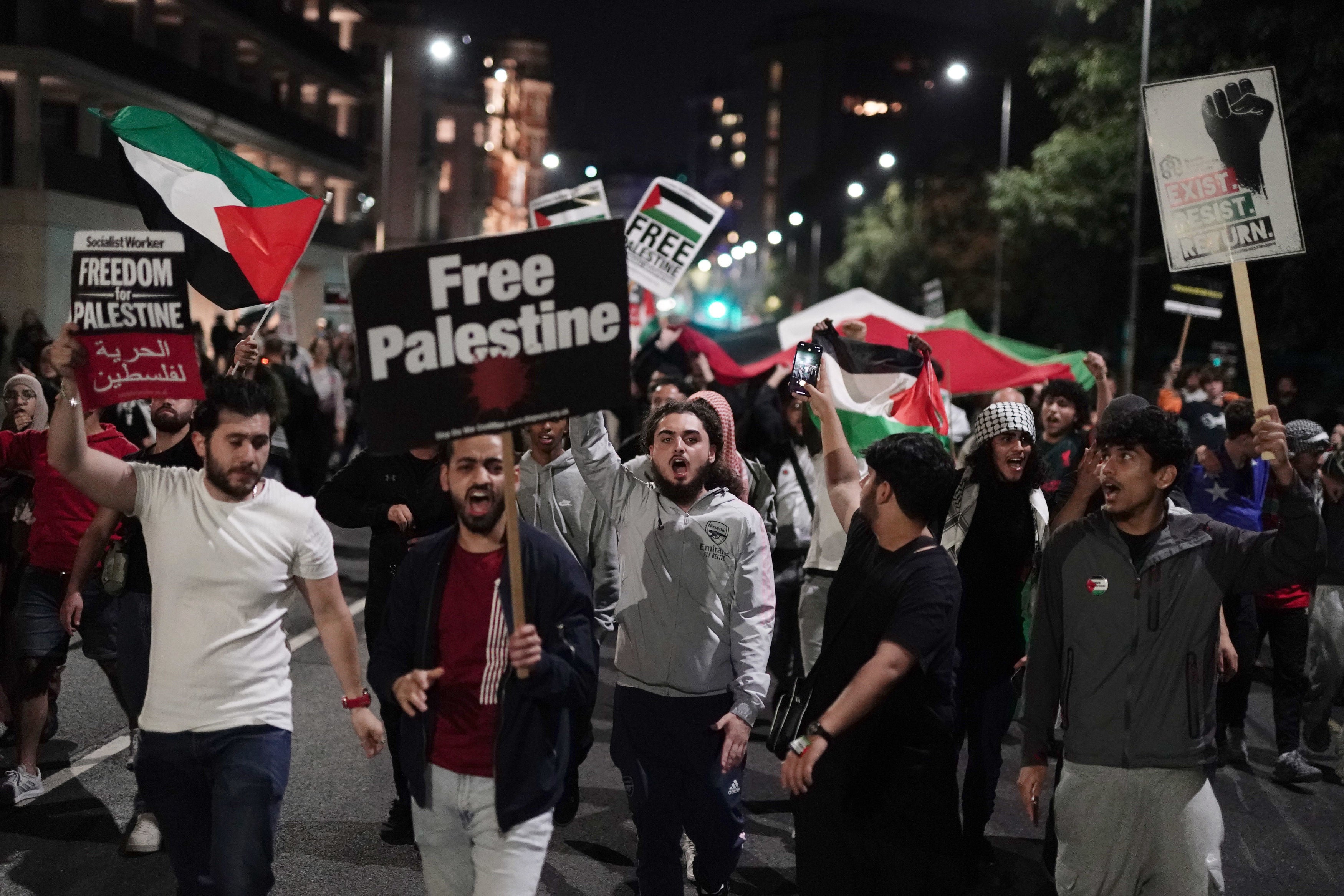 People take part in a Palestine Solidarity Campaign demonstration near the Israeli Embassy in Kensingston