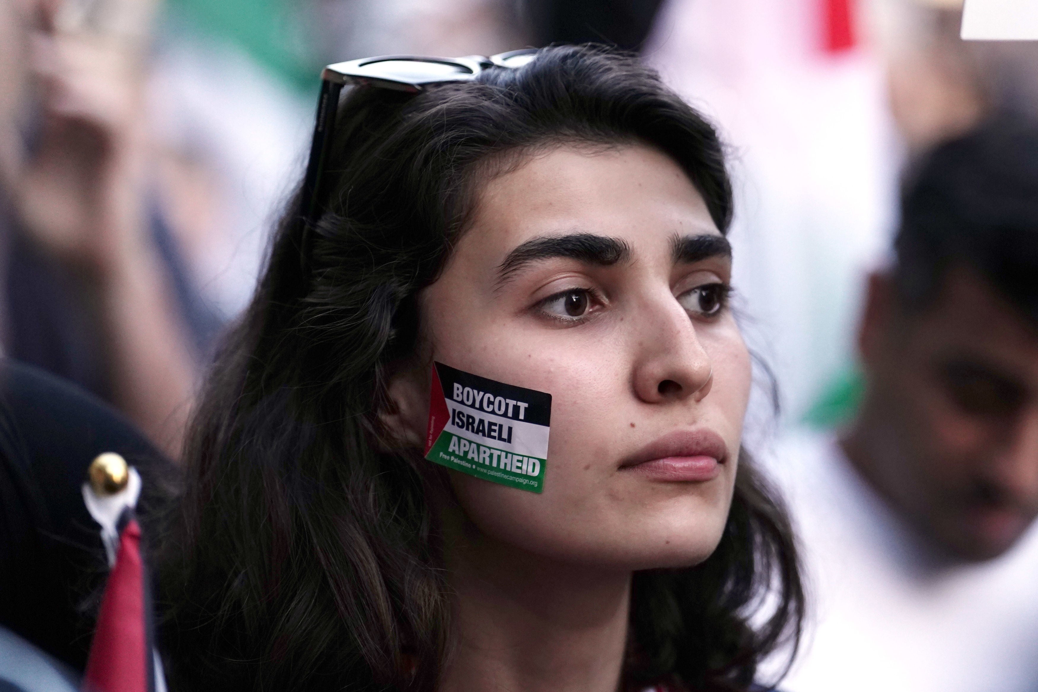 People take part in a Palestine Solidarity Campaign demonstration near the Israeli Embassy in Kensingston