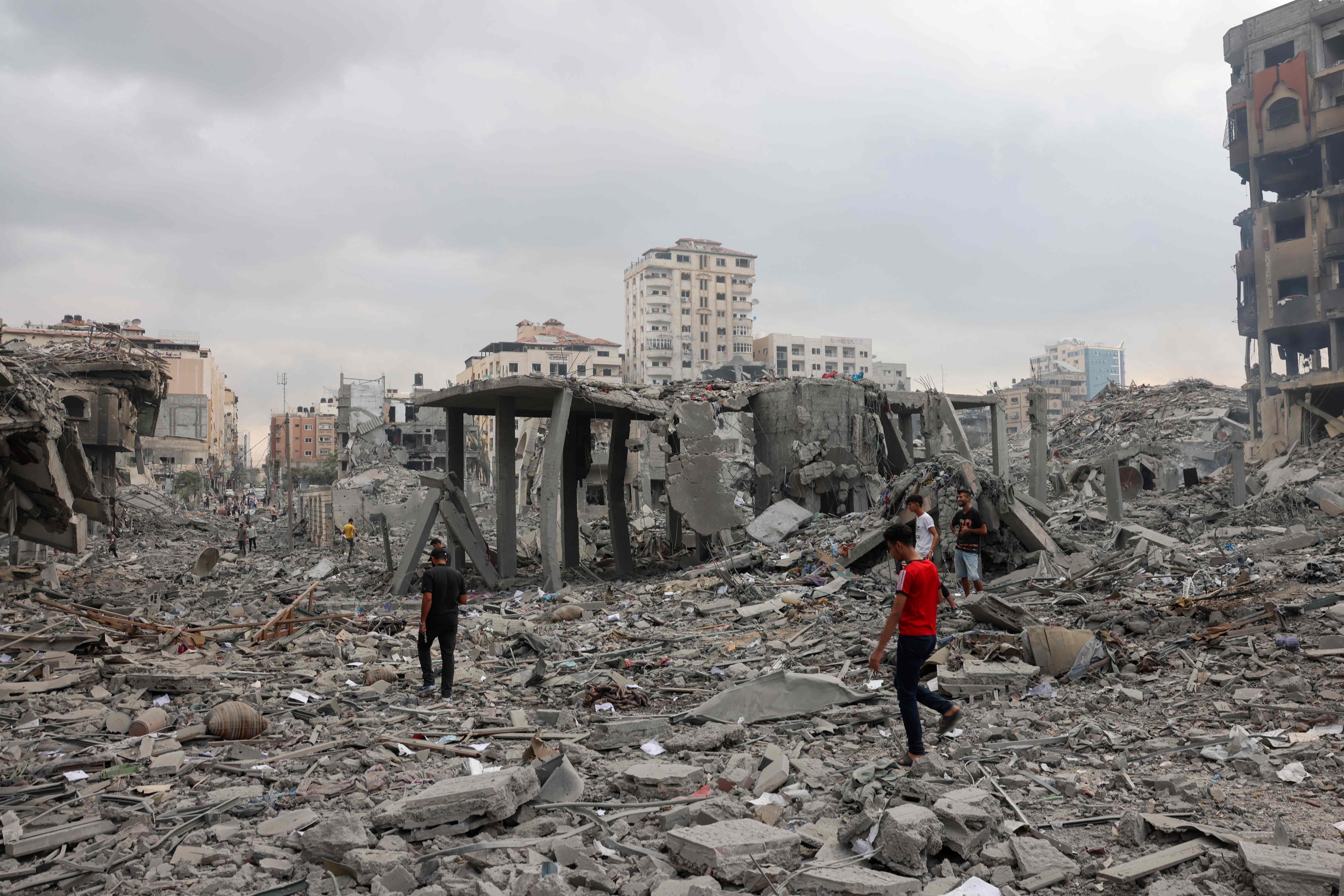 Palestinians inspect the destruction from Israeli airstrike in Gaza