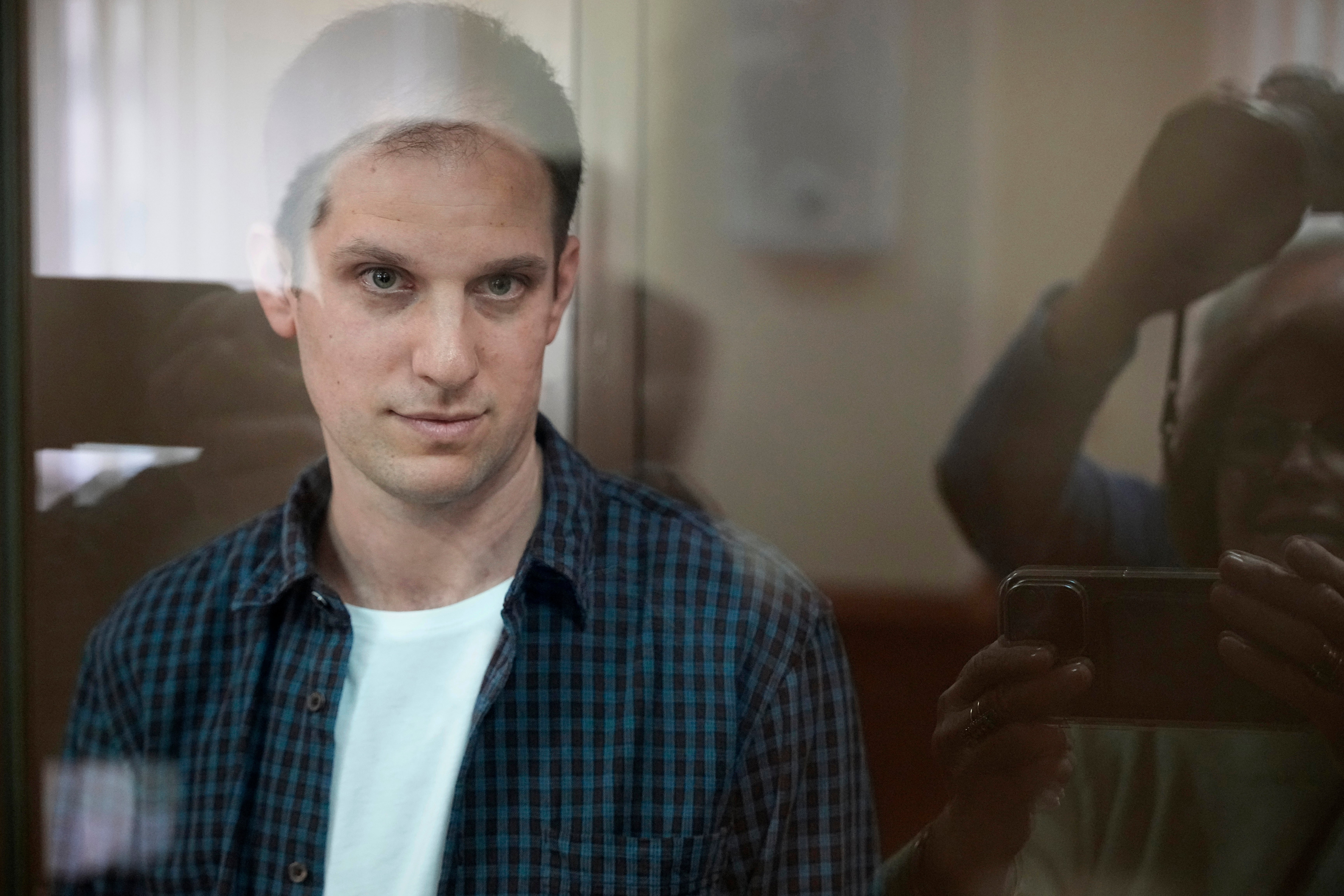 Wall Street Journal reporter Evan Gershkovich stands in a glass cage in a courtroom at the Moscow City Cour