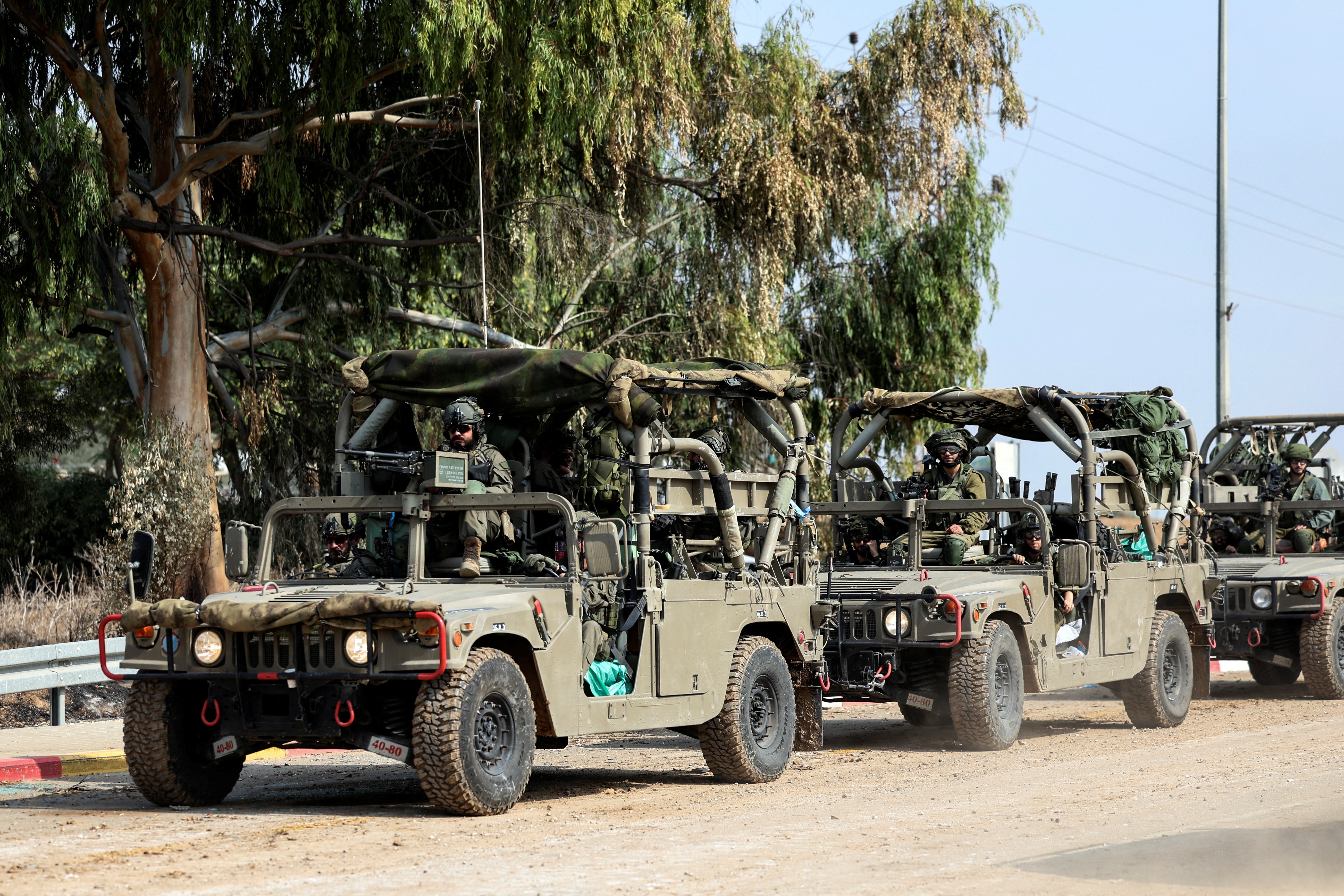 Israeli soldiers drive in military vehicles by Israel's border with Gaza in southern Israel
