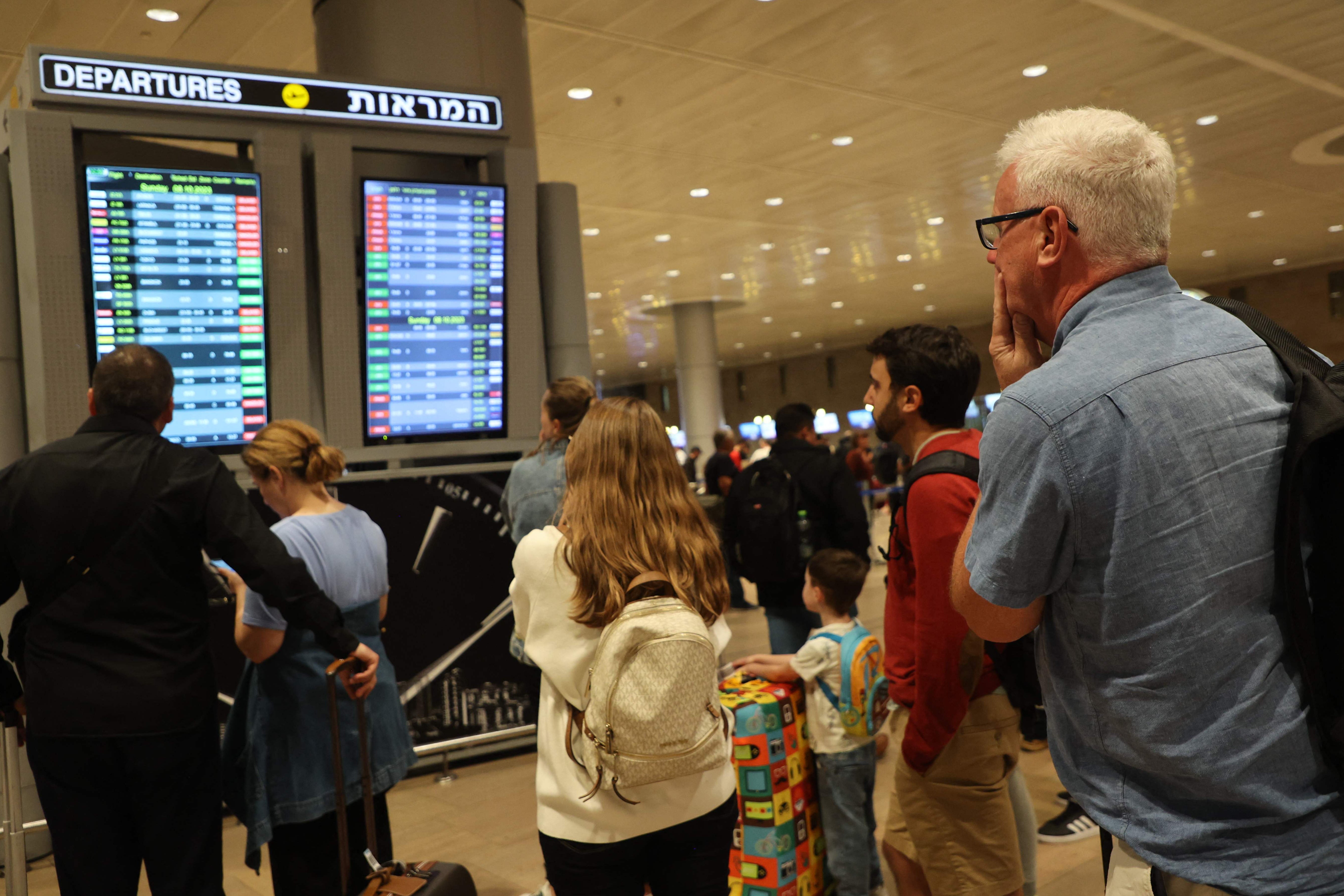 Passengers look at a departure board at Ben Gurion Airport near Tel Aviv, Israel