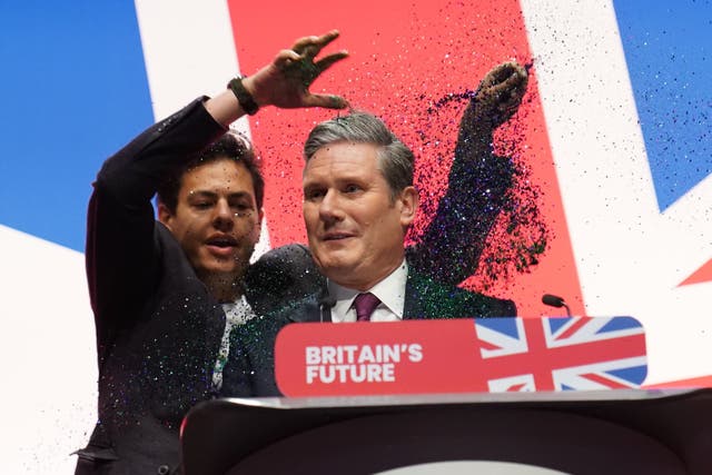 A protester throws glitter over Labour leader Sir Keir Starmer (Stefan Rousseau/PA)