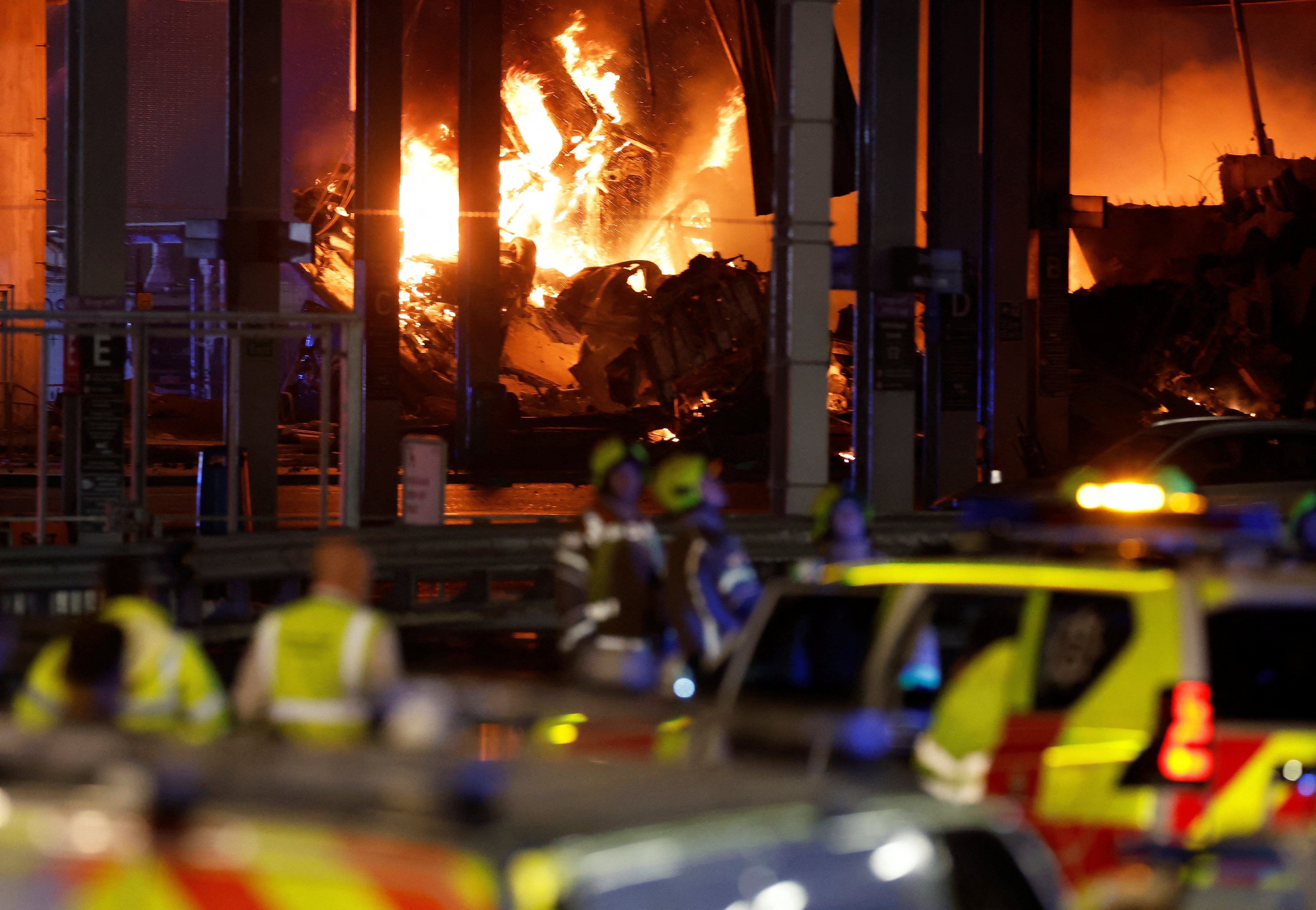 Flames are seen as emergency services respond to a fire in Terminal Car Park 2 at London Luton Airport