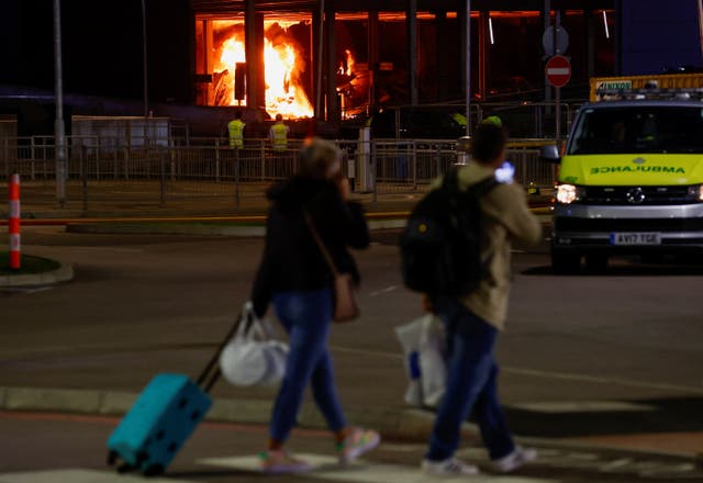 <p>People leave as emergency services respond to a fire in Terminal Car Park 2 at Luton Airport</p>