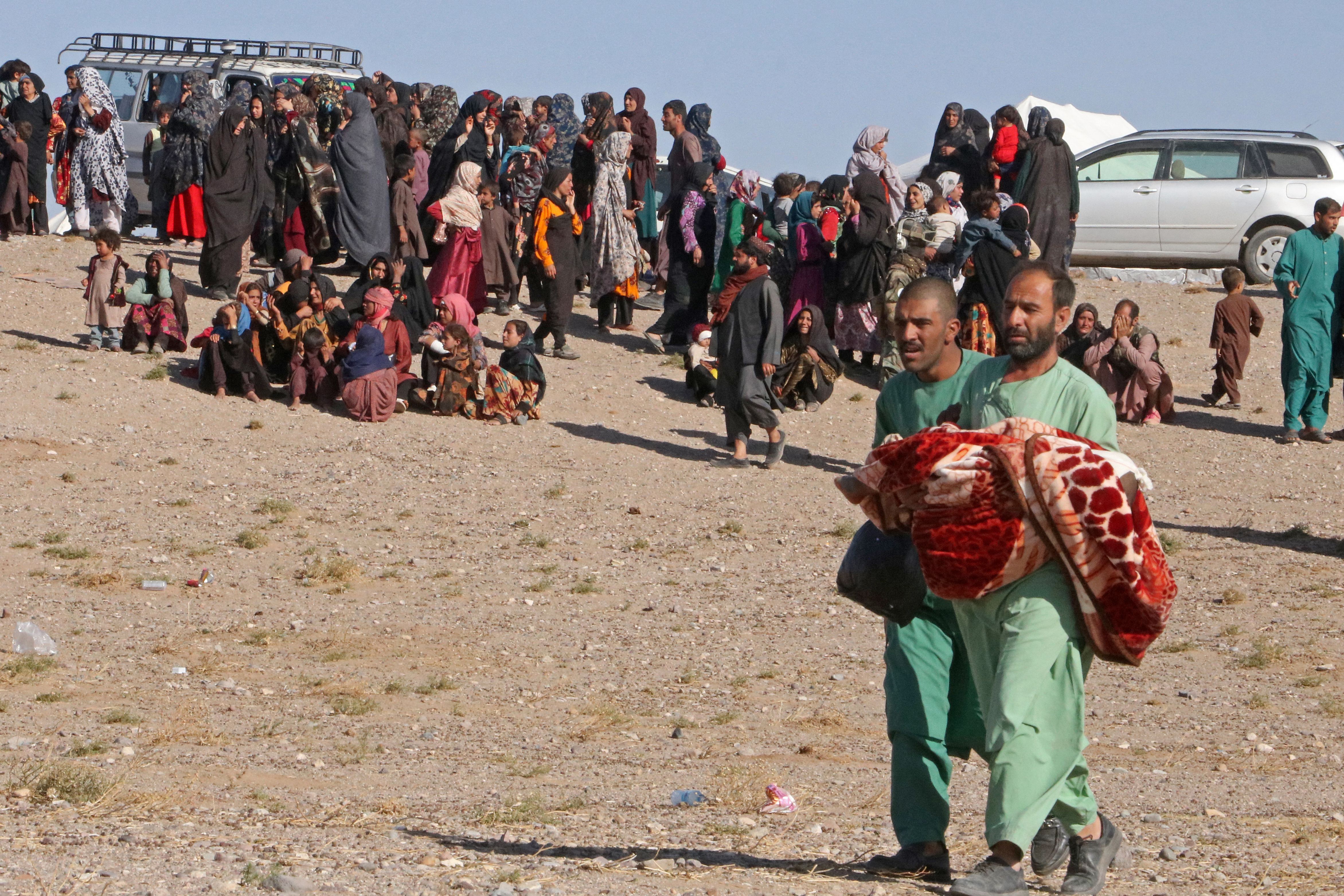 <p>An Afghan man carries a child during a mass funeral for the people killed in a series of earthquakes in Zinda Jan district of Herat province, Afghanistan </p>