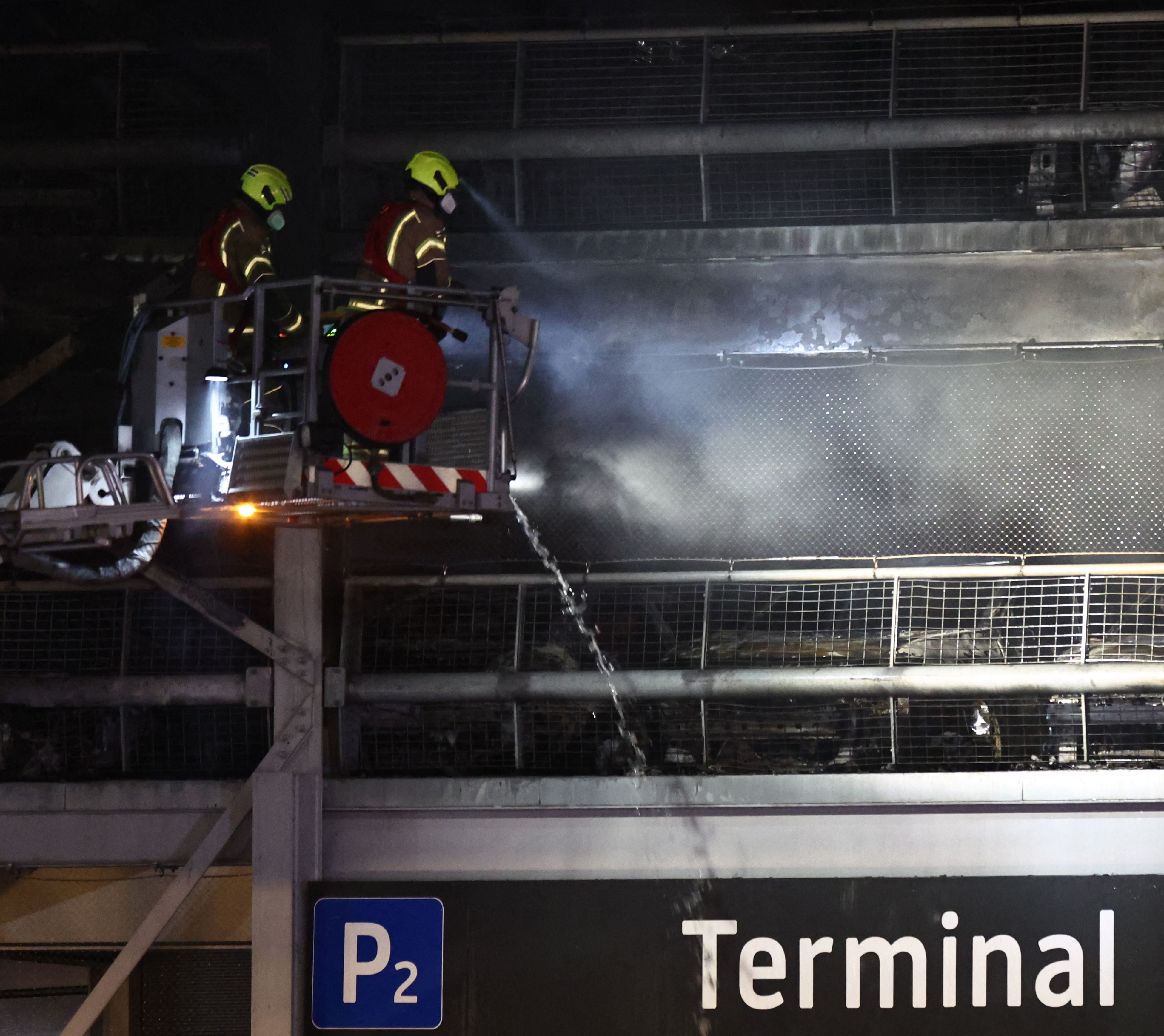 Firemen battle a fire at London's Luton Airport which caused a partial collapse of a parking structure