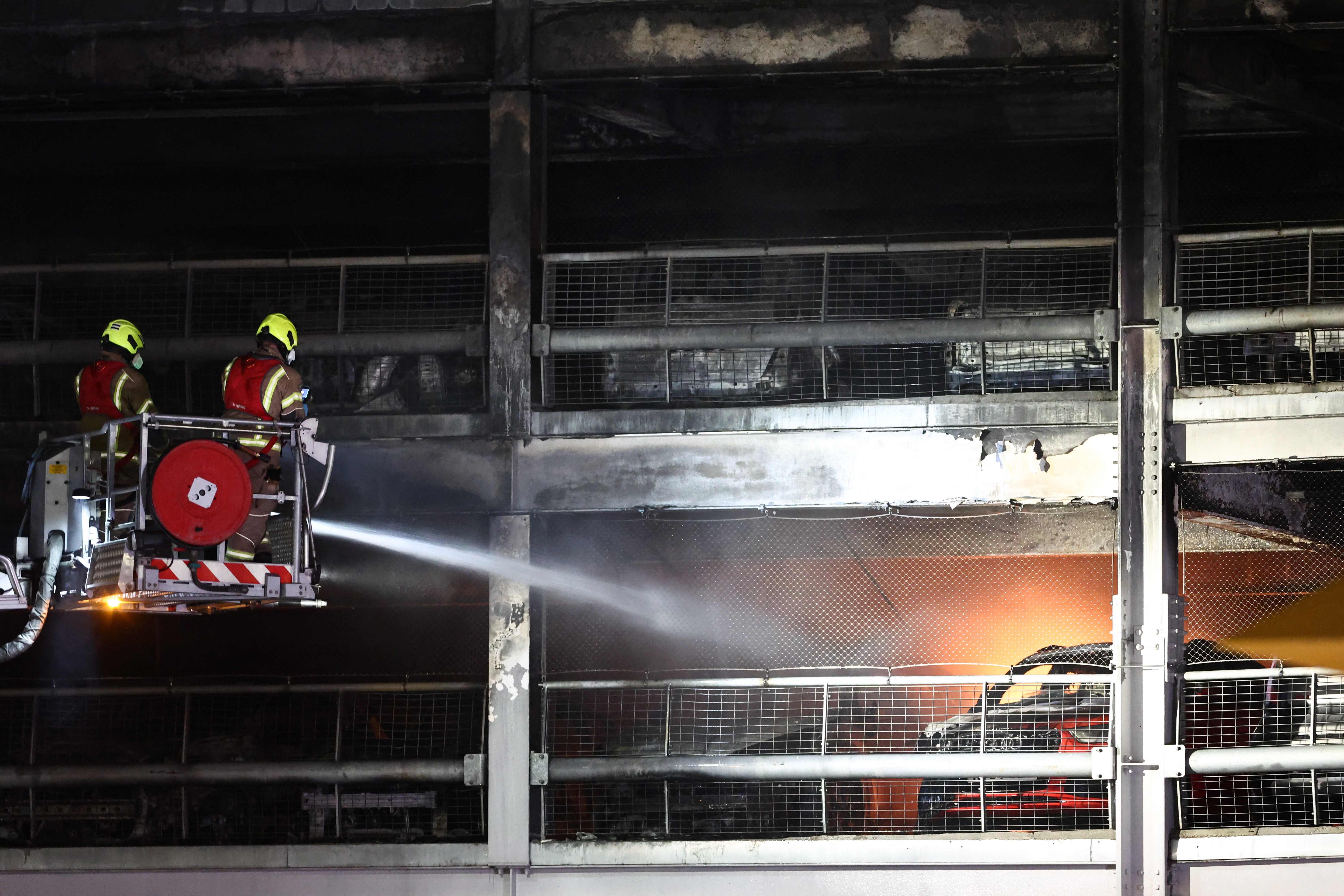 Firemen battle a fire at London's Luton Airport which caused a partial collapse of a parking structure