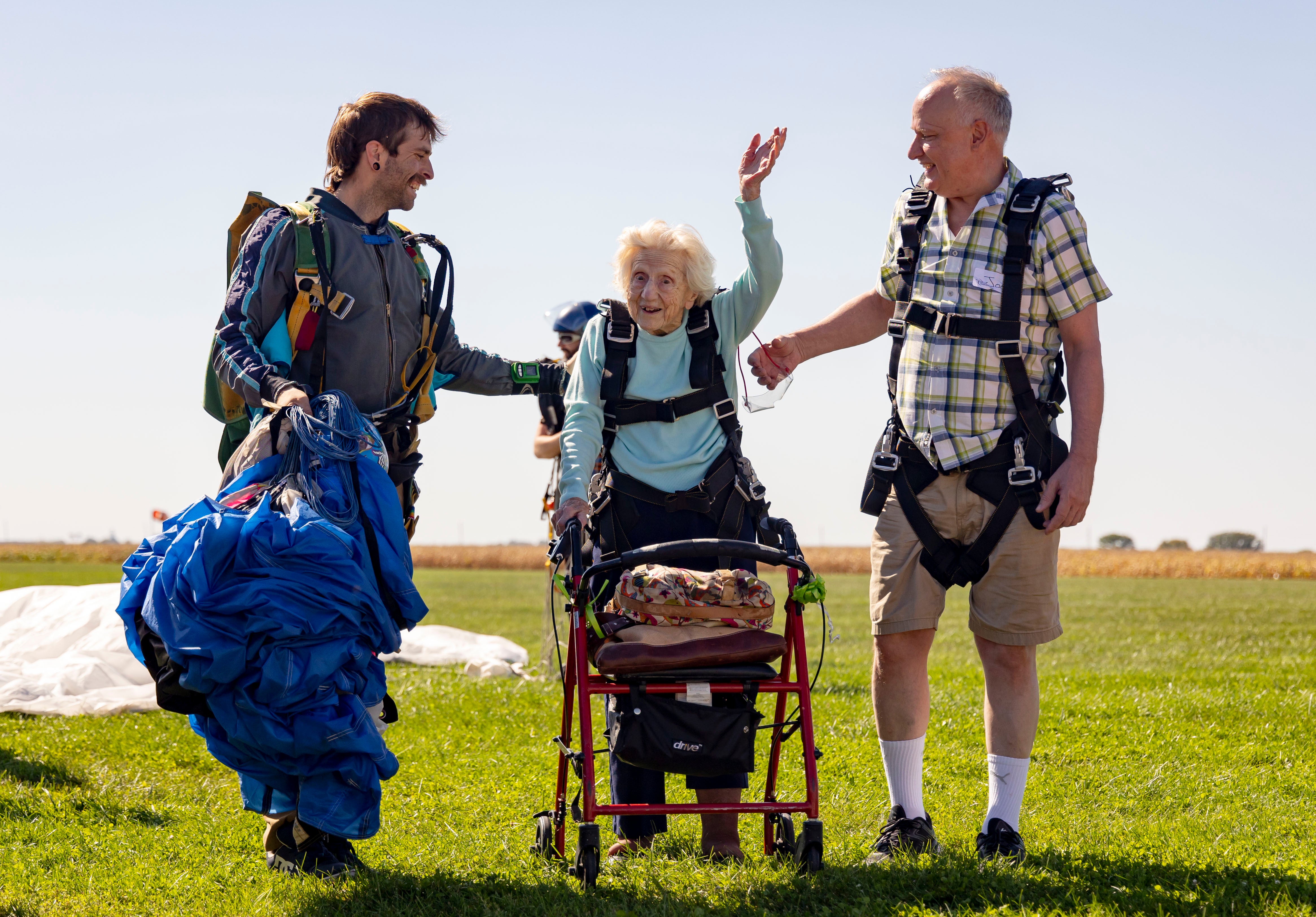 Dorothy Hoffner, 104, waves to the crowd with Daniel Wilsey (left) and friend Joe Conant on 1 October