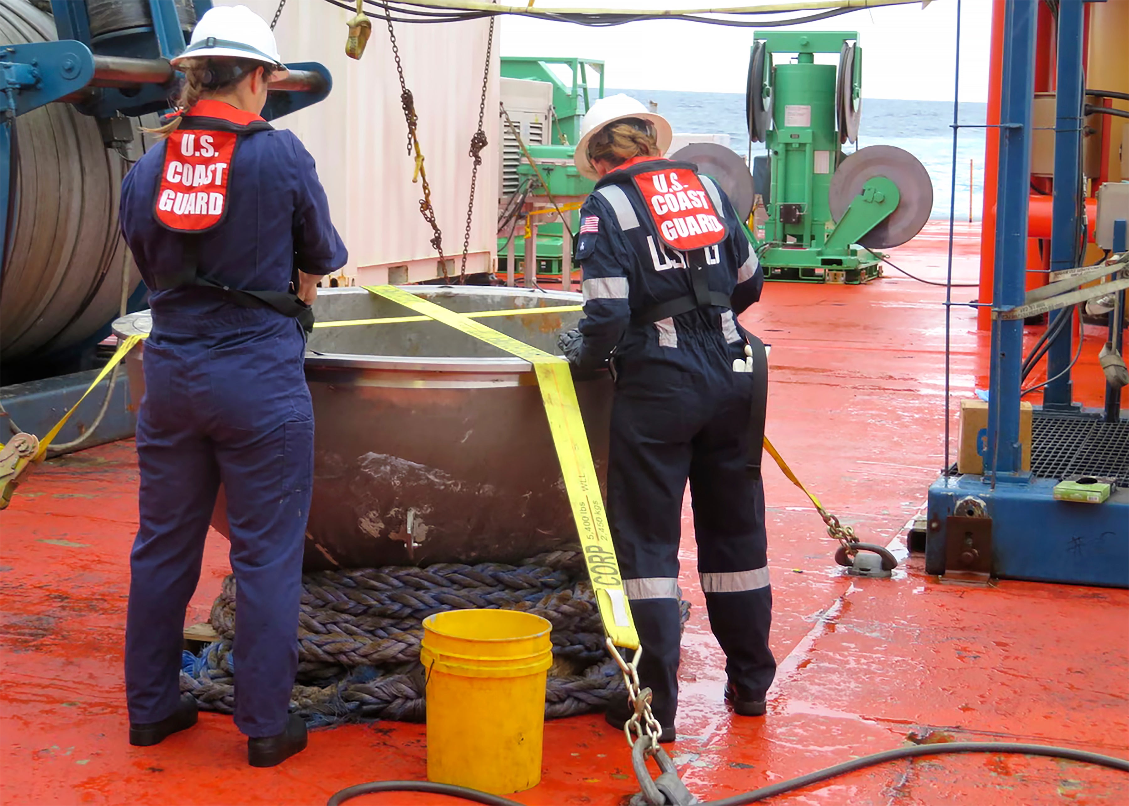US Coast Guard marine safety engineers conduct a survey of the aft titanium endcap from the Titan submersible