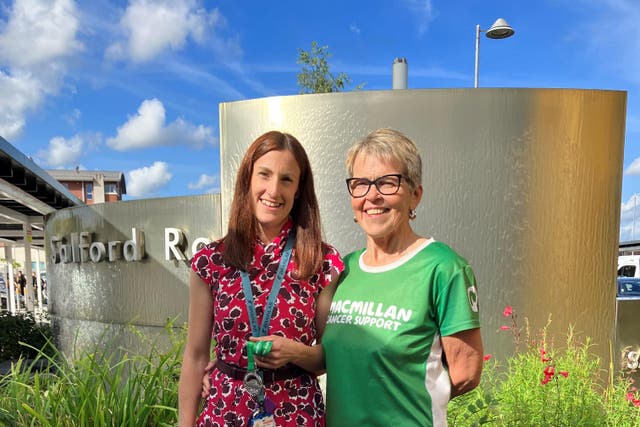 Bernie Burke, 61, who completed a Macmillan Mighty Hike two months after a brain haemorrhage, handed her medal to surgeon Helen Raffalli-Ebezant (Macmillan Cancer Support/PA)