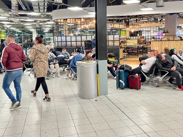 <p>Waiting game: passengers stranded all night at Luton airport after a car park fire caused the cancellation of their flights</p>