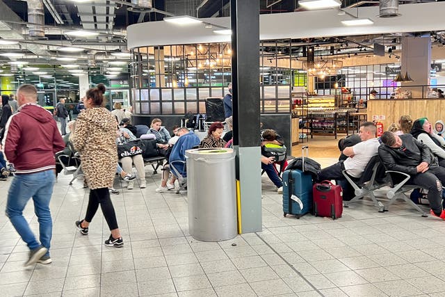 <p>Waiting game: passengers stranded all night at Luton airport after a car park fire caused the cancellation of their flights</p>