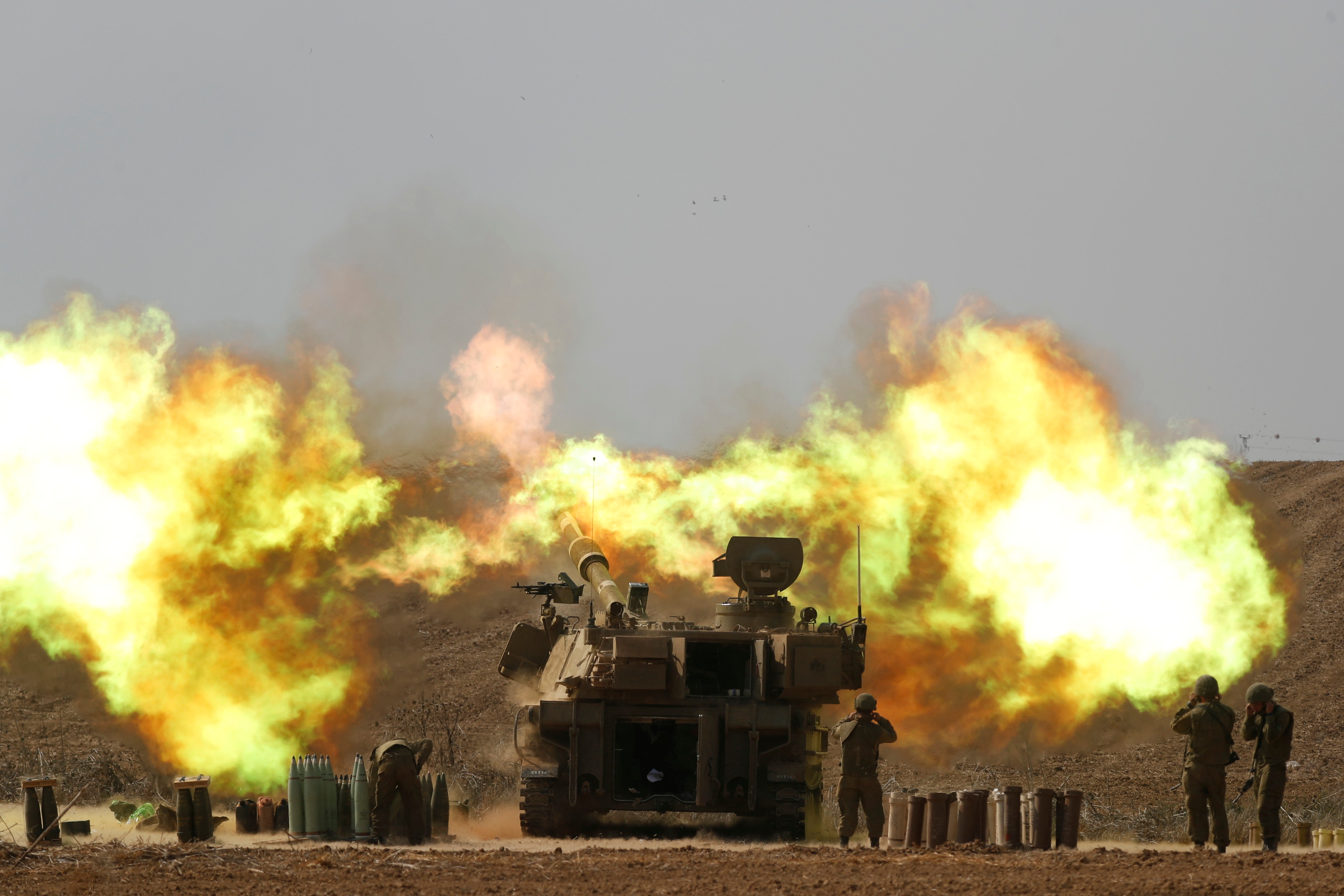 An Israeli artillery unit fires towards Gaza along the border in southern Israel on Wednesday