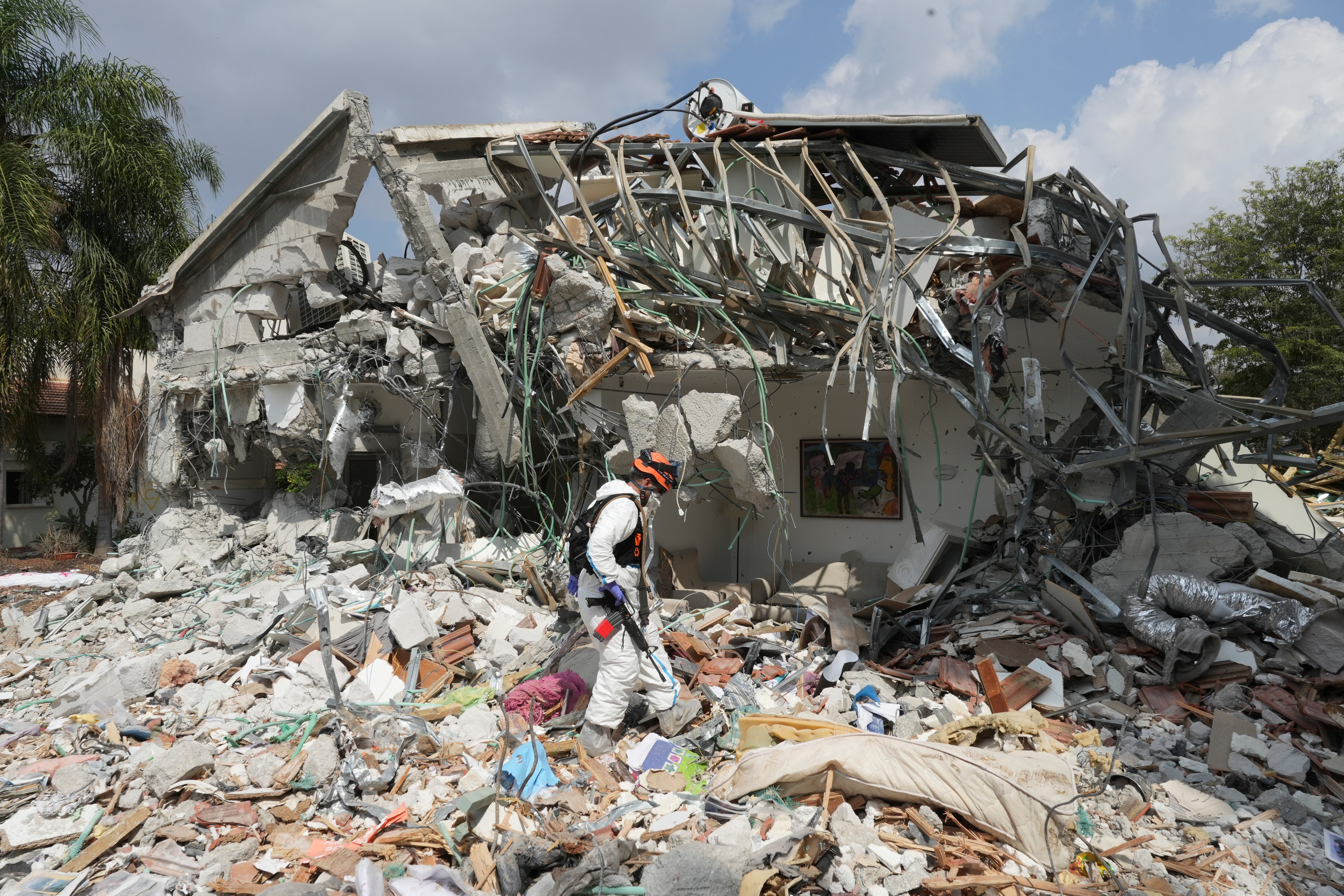 An Israeli soldier walks by a house destroyed by Hamas militants in Kibbutz Be’eri on Wednesday, Oct. 11