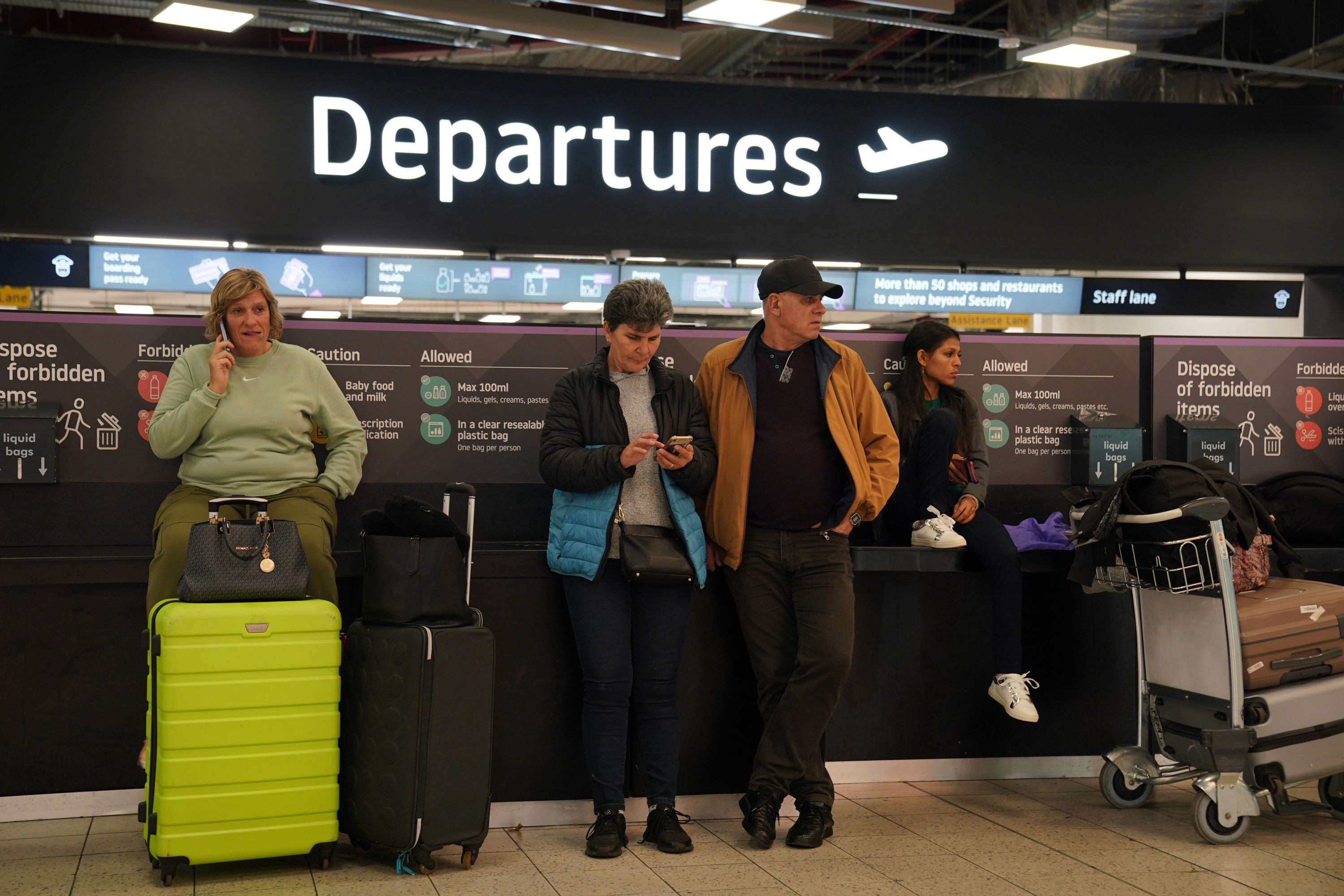 Passengers wait at Luton airport after it was closed following a fire that ripped through a multi-storey car park causing it to collapse