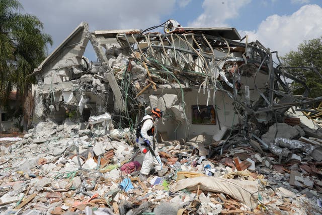 <p>An Israeli soldier walks past a house destroyed by Hamas militants in Kibbutz Be'eri </p>