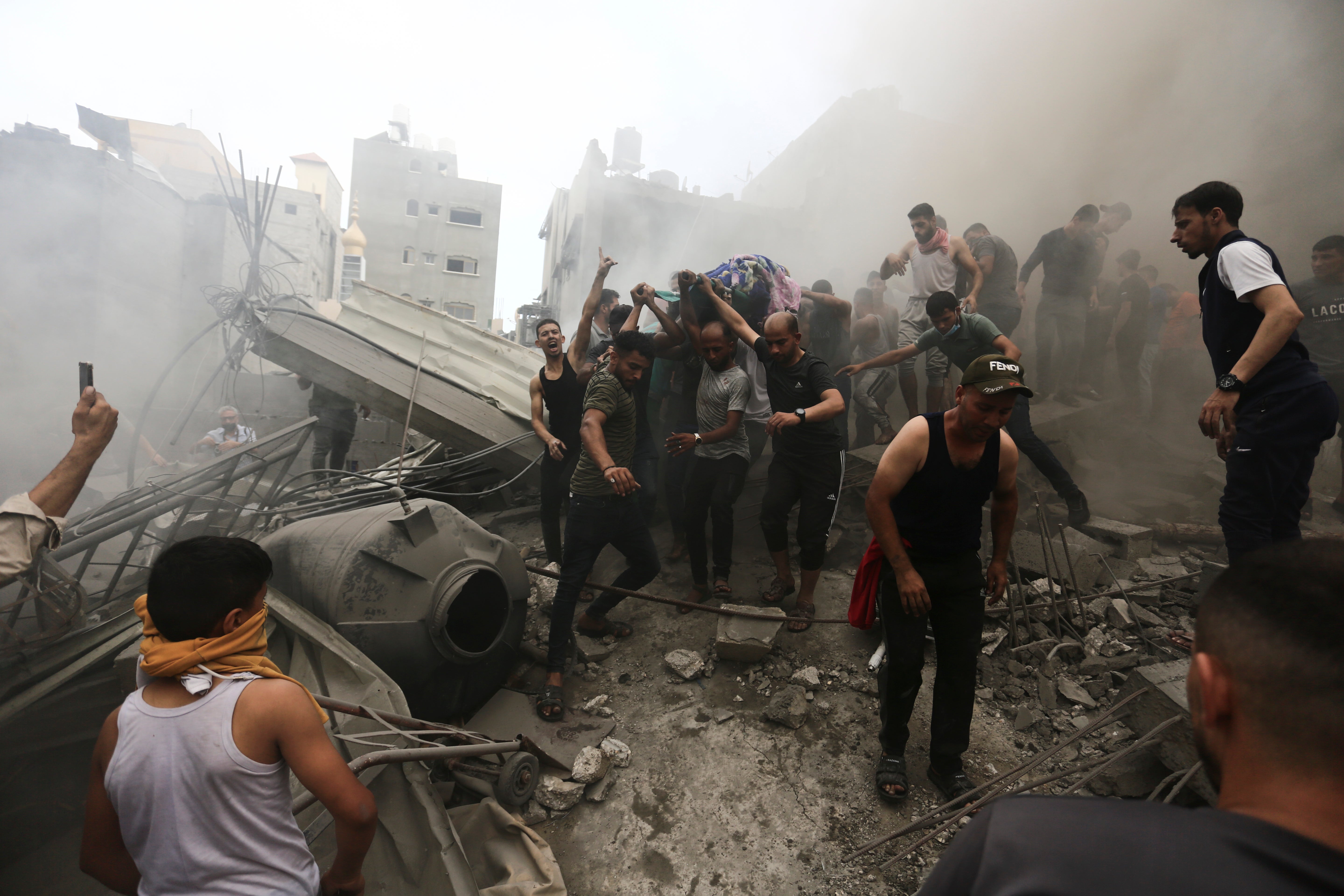 Palestinians remove a dead body from the rubble of a building after an Israeli airstrike Jebaliya refugee camp
