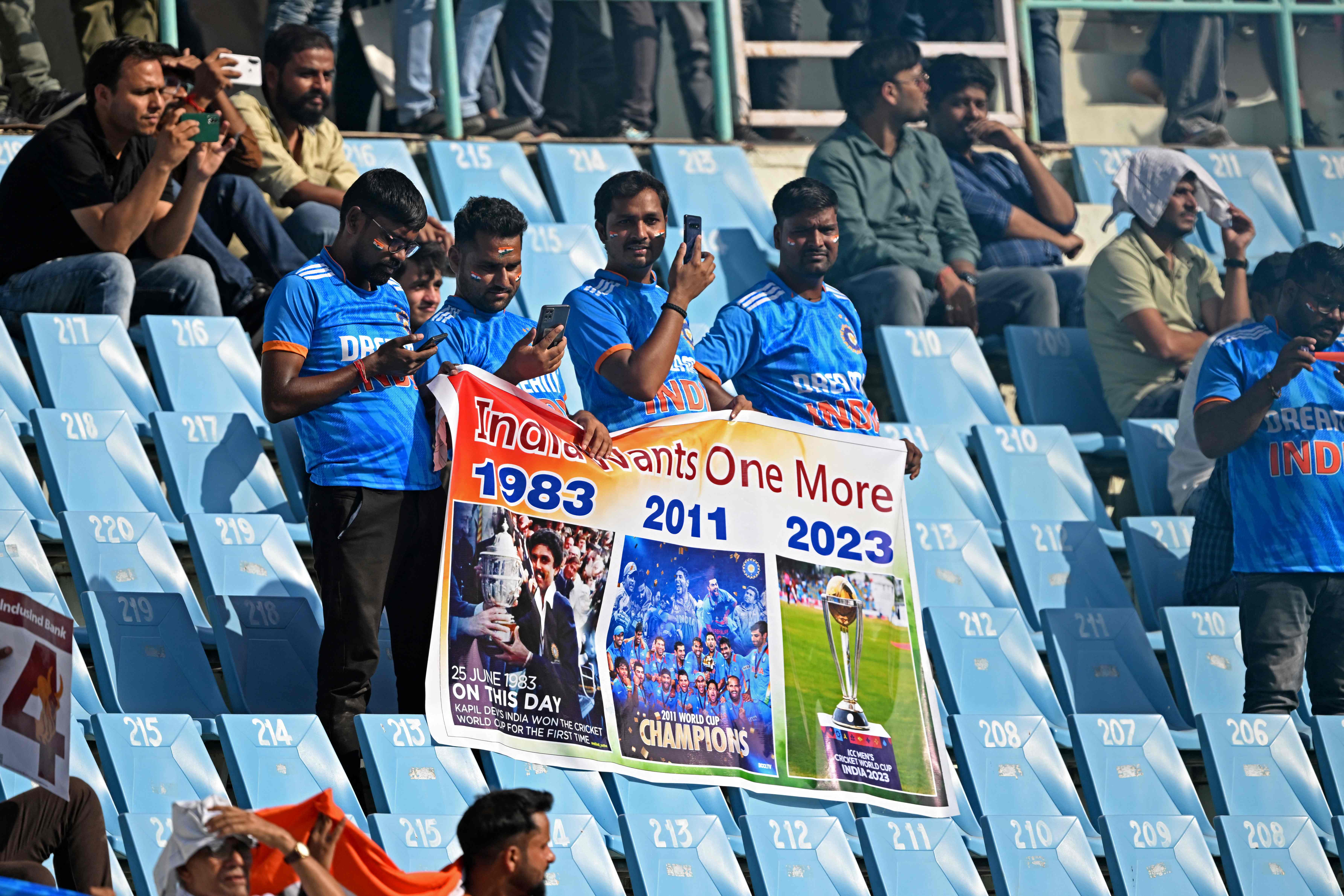 Indian fans hold a poster as they watch the 2023 ICC Men’s Cricket World Cup one-day international (ODI) match between Australia and South Africa on 12 October