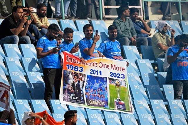 <p>Indian fans hold a poster as they watch the 2023 ICC Men’s Cricket World Cup one-day international (ODI) match between Australia and South Africa on 12 October </p>