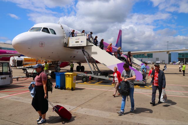 <p>Passengers disembark Wizz Air Airbus A320 low coast plane at London Luton Airport</p>