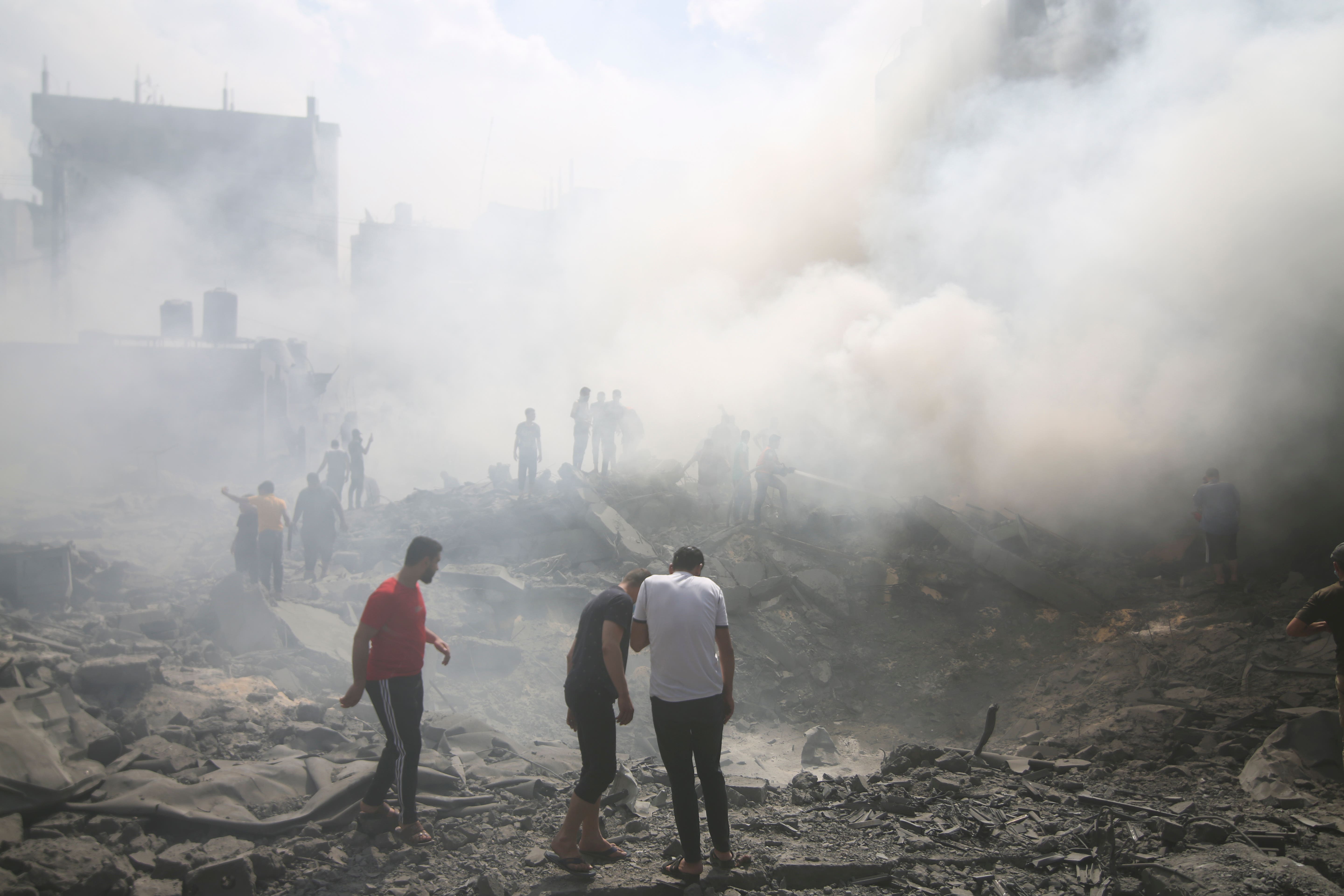 Palestinians look for survivors after an Israeli airstrike in southern Gaza (Hatem Ali/AP)