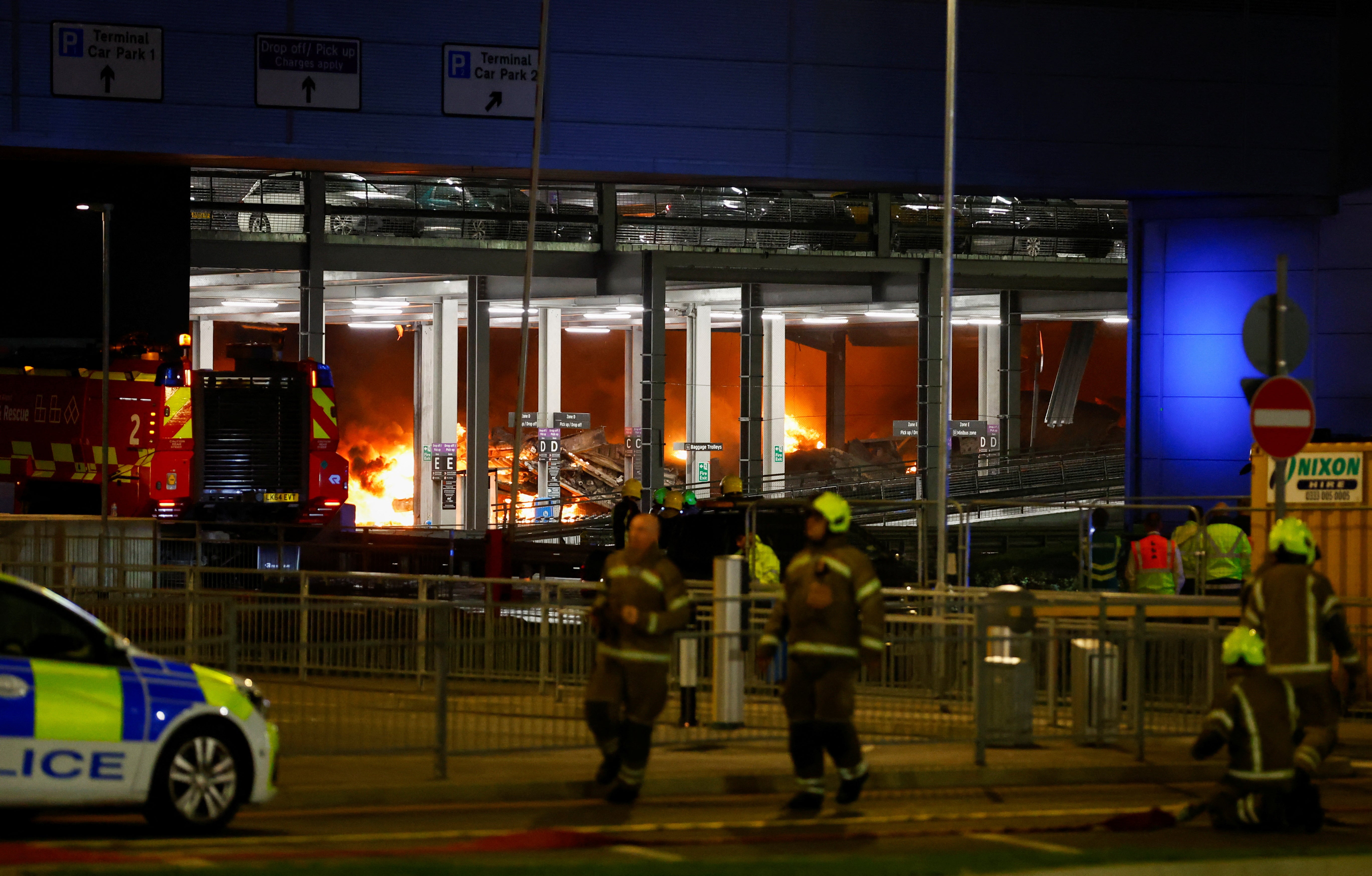 Flames are seen as emergency services respond to the fire in Terminal Car Park 2 at London Luton airport in Luton