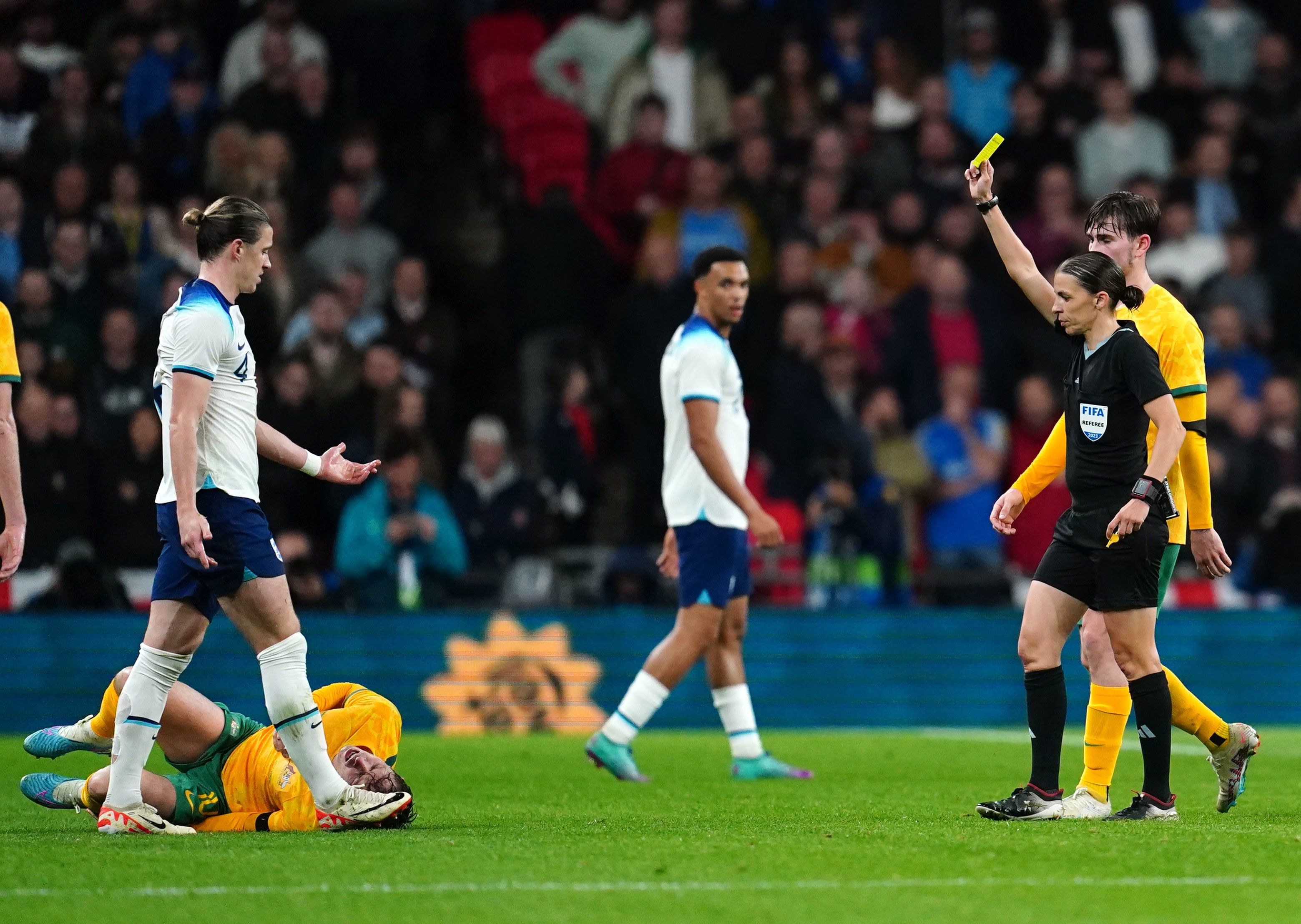 Referee Stephanie Frappart shows a yellow card to England's Conor Gallagher
