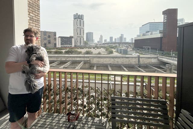 <p>Stratford resident Andrew Nix, with his dog, Vader: a ‘hulking, floodlit’ MSG Sphere music venue could be sited 50 metres from his balcony </p>