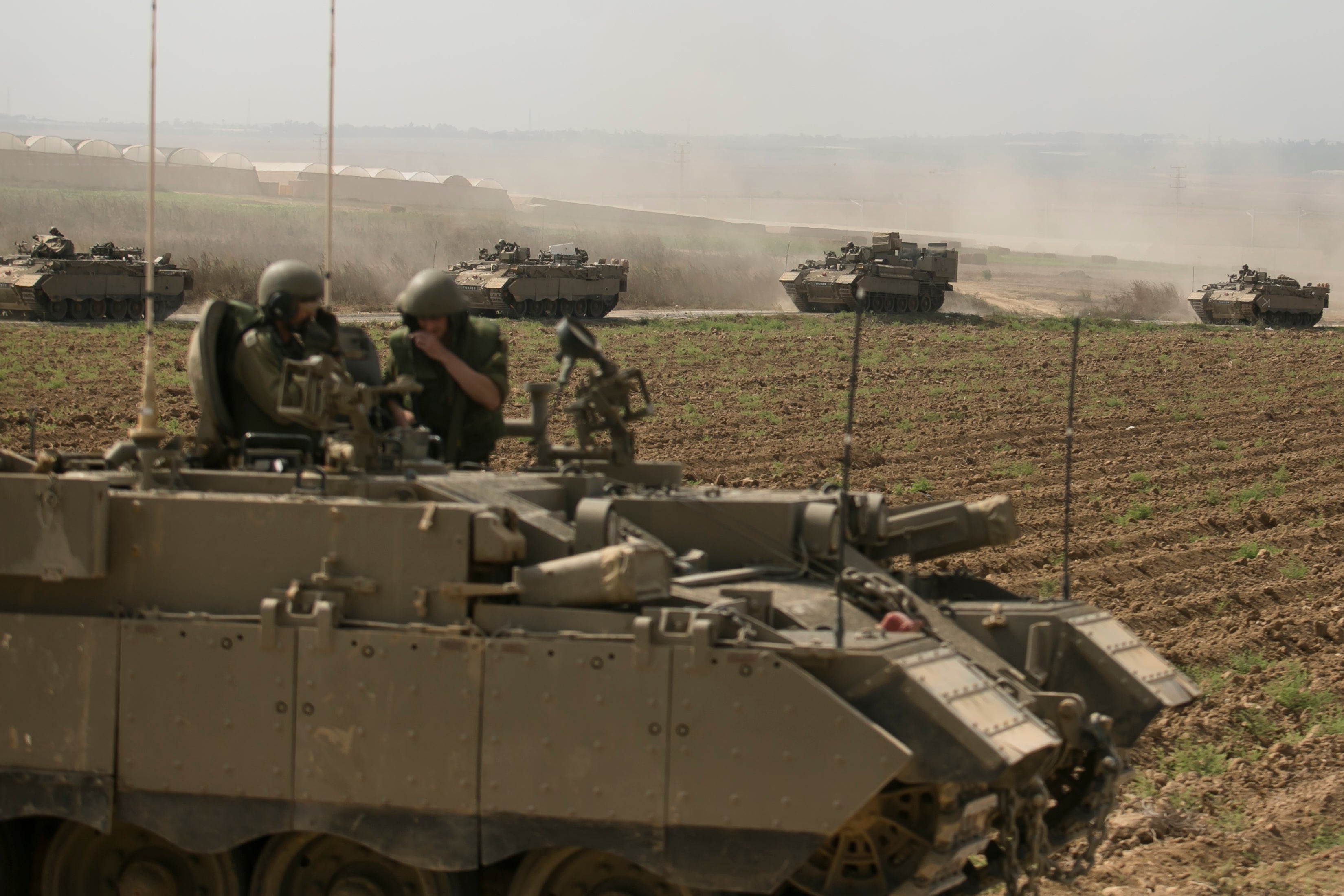 Israeli armor personnel carrier move in formation near the border with Gaza on October 14, 2023 in Near Sderot, Israel.
