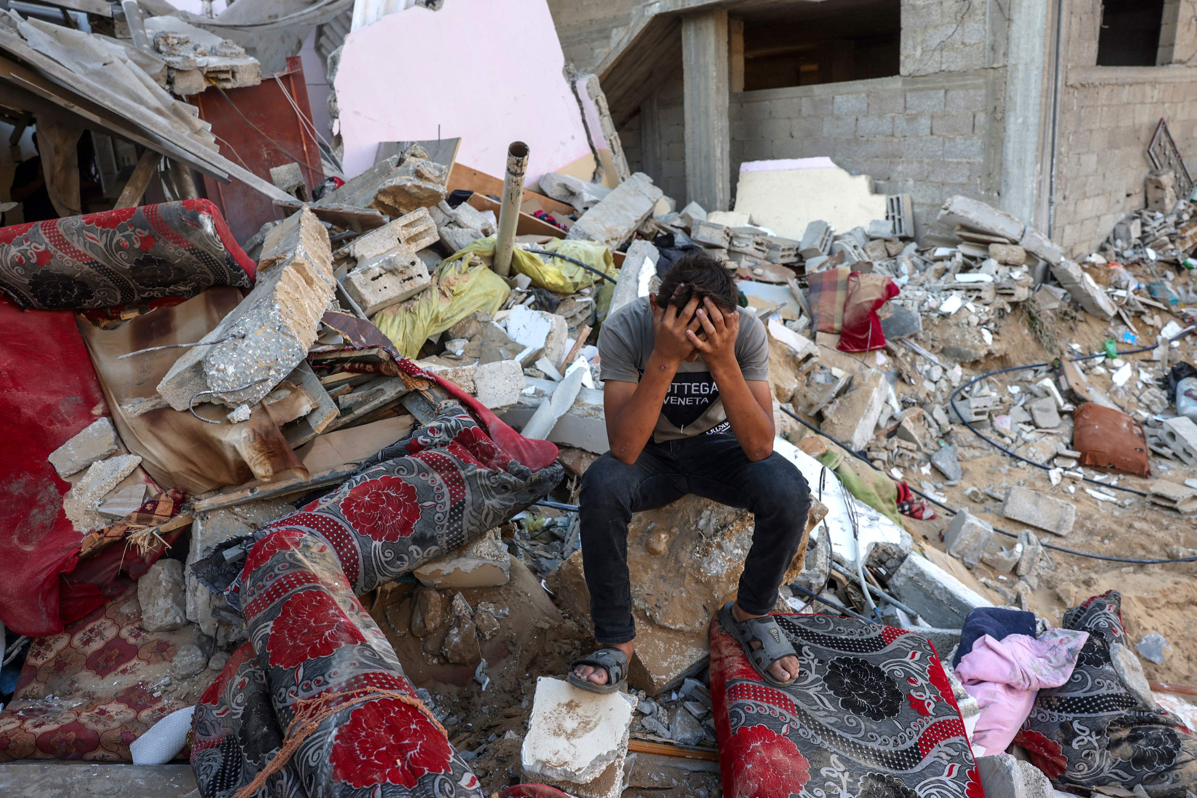 A Palestinian boy sits with his head in his hands after an Israeli airstrike