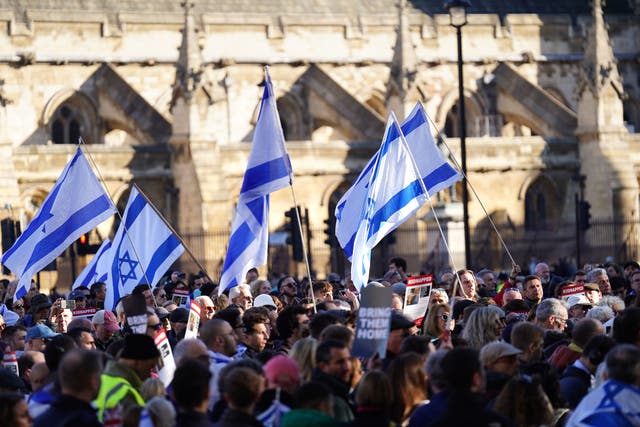 <p>Israeli flags are waved by activists marching to Parliament Square </p>
