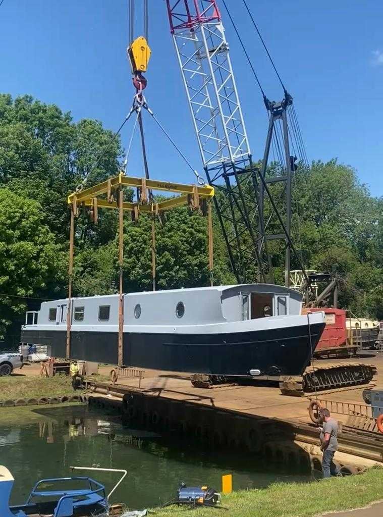 The couple’s brand new shell of a boat is lowered onto the River Lea