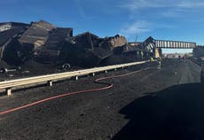 Colorado train derails, spilling train cars and coal onto a highway and trapping a semi-truck driver