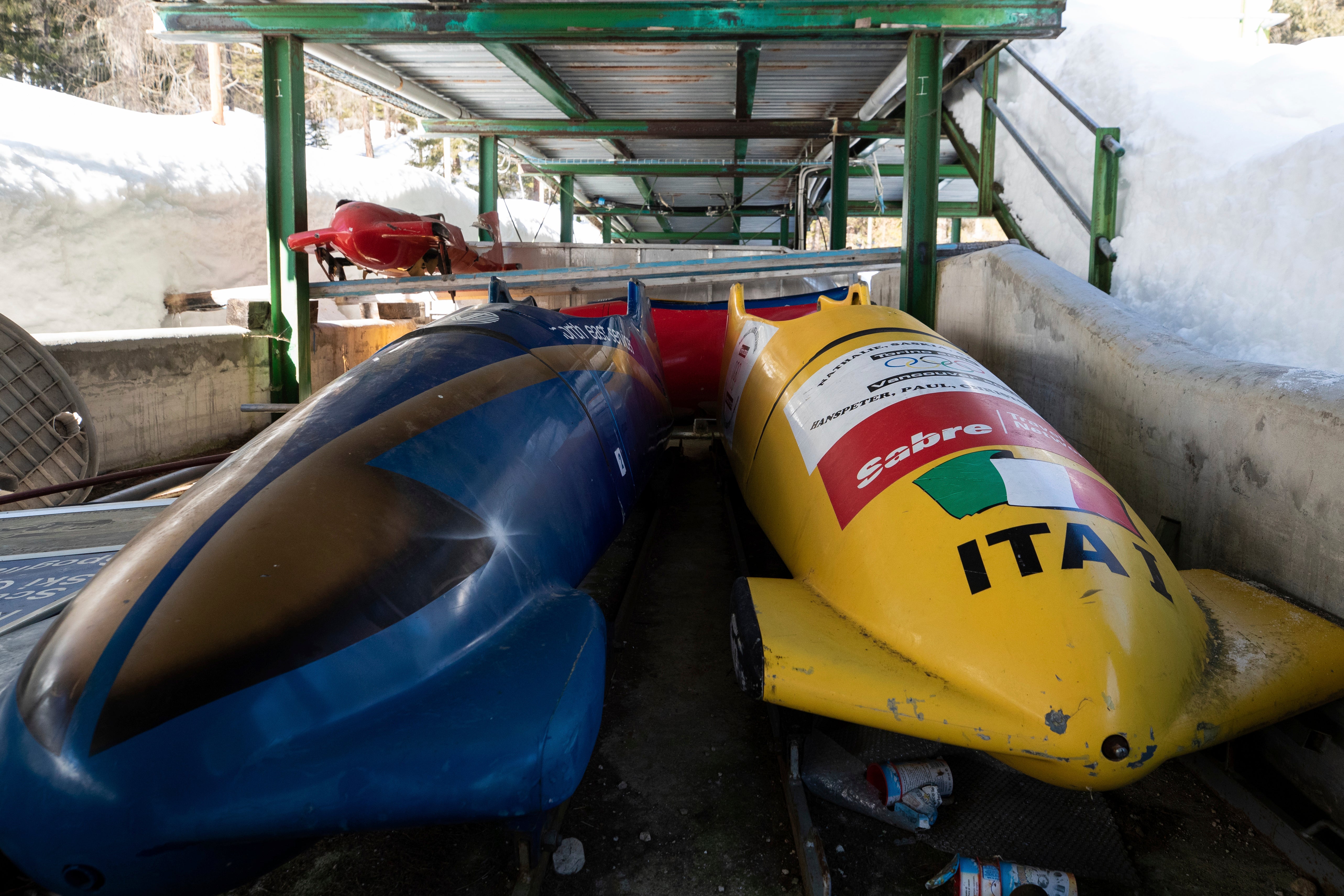 Bobsleds are parked next to the track in Cortina d'Ampezzo, Italy,